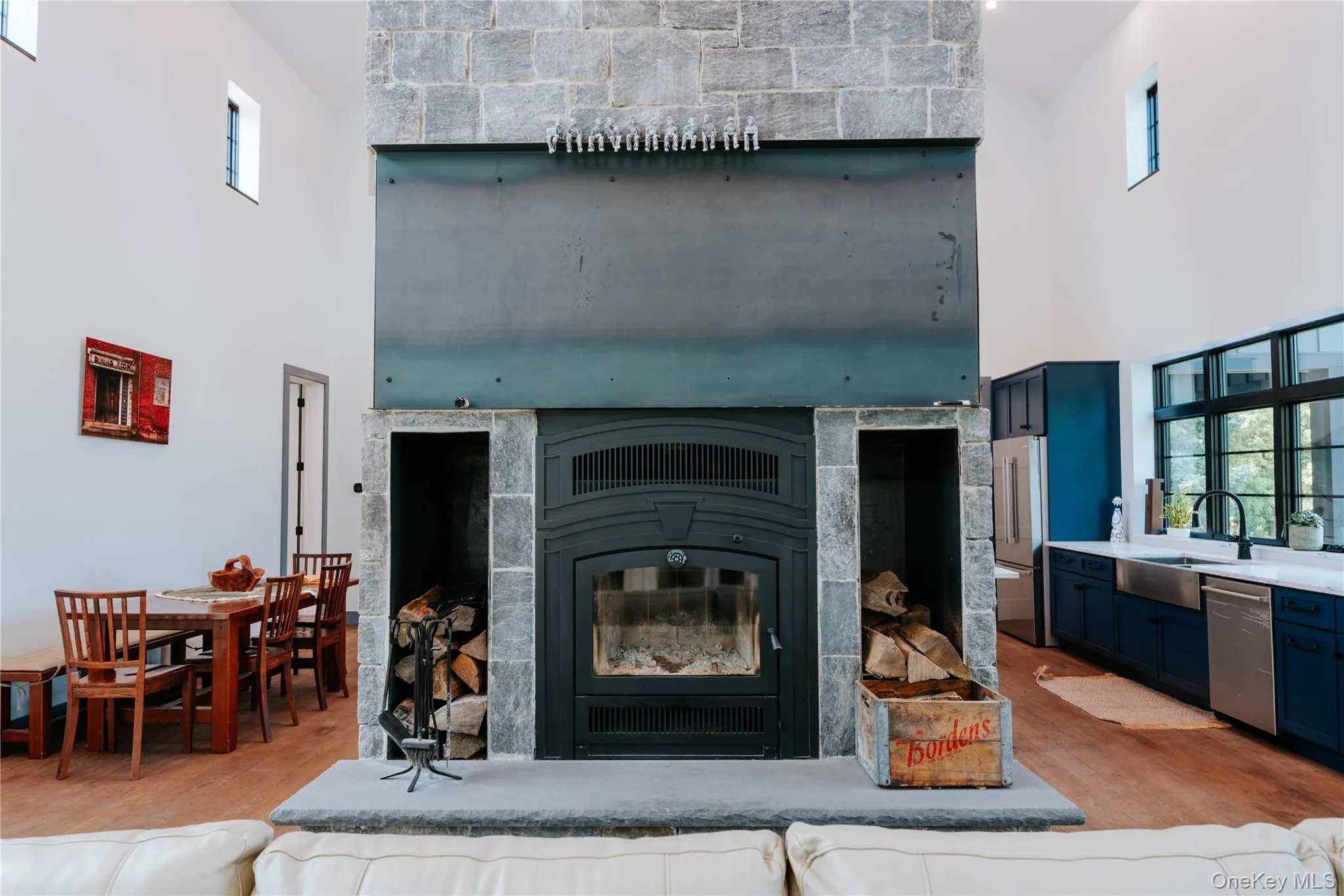 Detailed view of appliances with stainless steel finishes, wood finished floors, and a glass covered fireplace Detailed view of appliances with stainless steel finishes, wood finished floors, and a glass covered fireplace