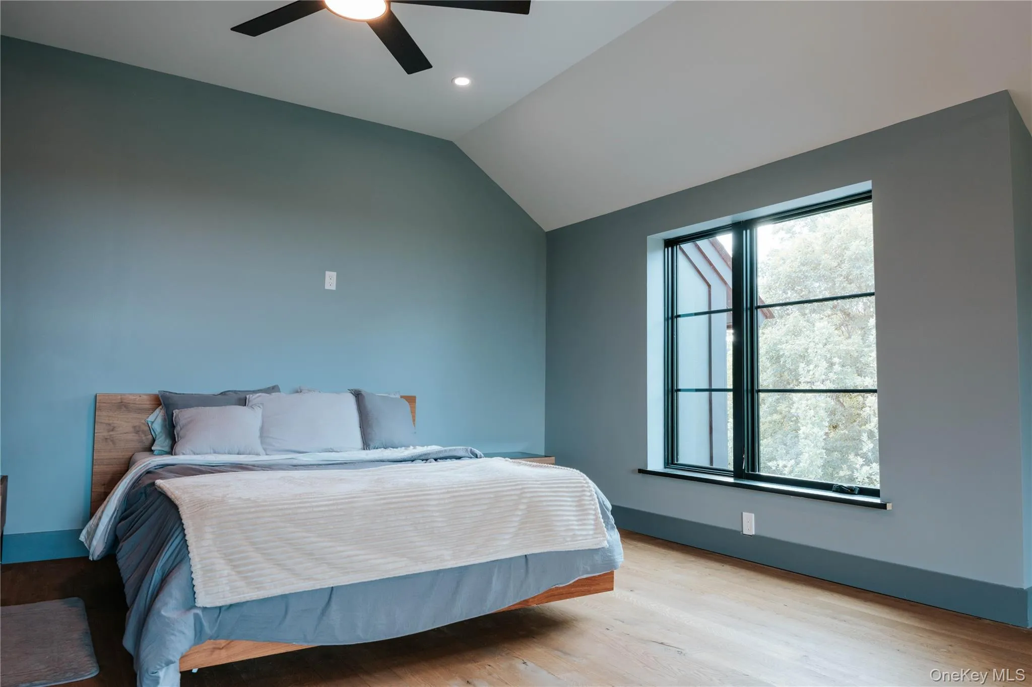 Bedroom featuring light wood-style floors, vaulted ceiling, recessed lighting, and a ceiling fan Bedroom featuring light wood-style floors, vaulted ceiling, recessed lighting, and a ceiling fan