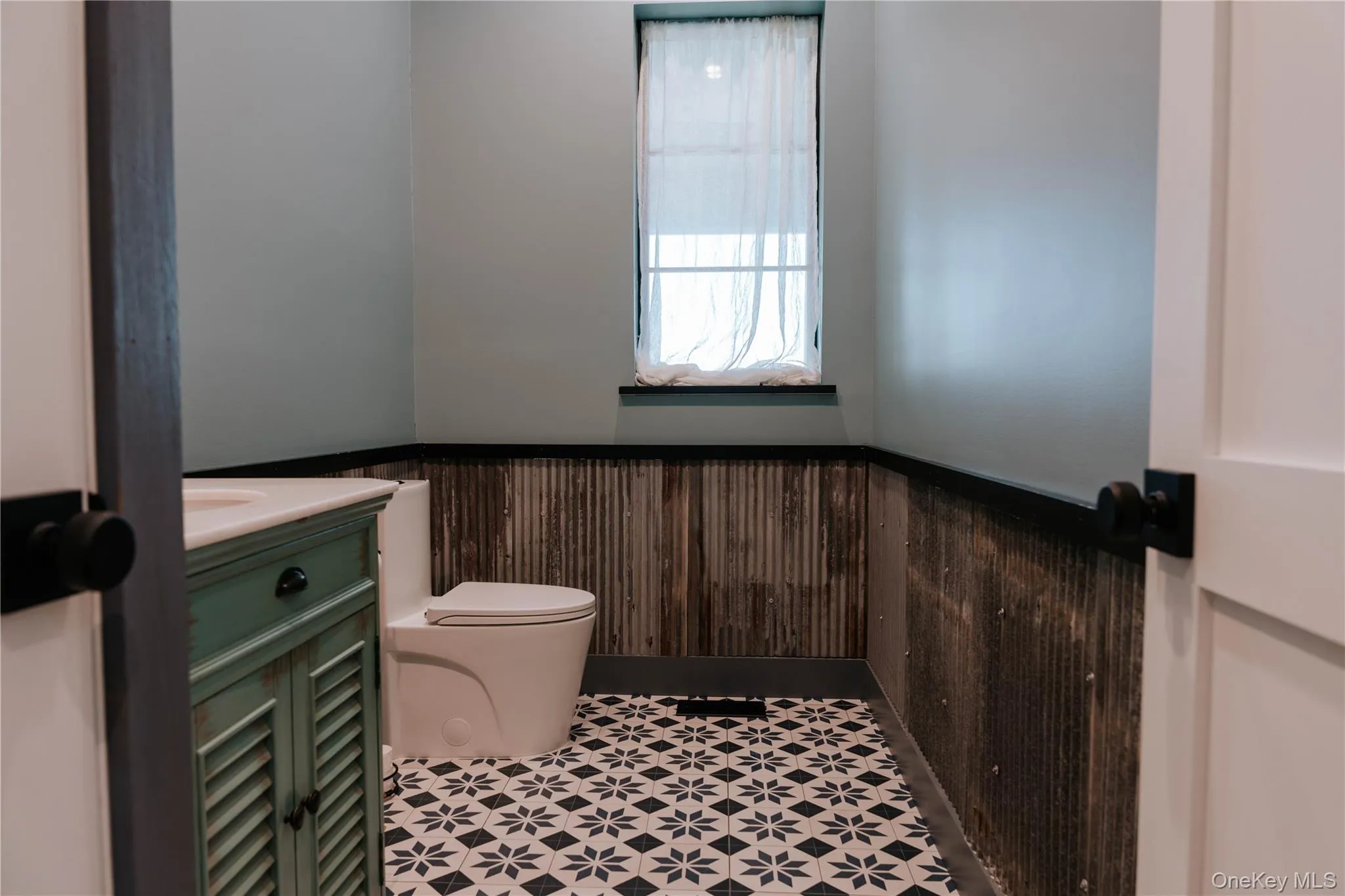 Bathroom with wainscoting, vanity, and wooden walls Bathroom with wainscoting, vanity, and wooden walls