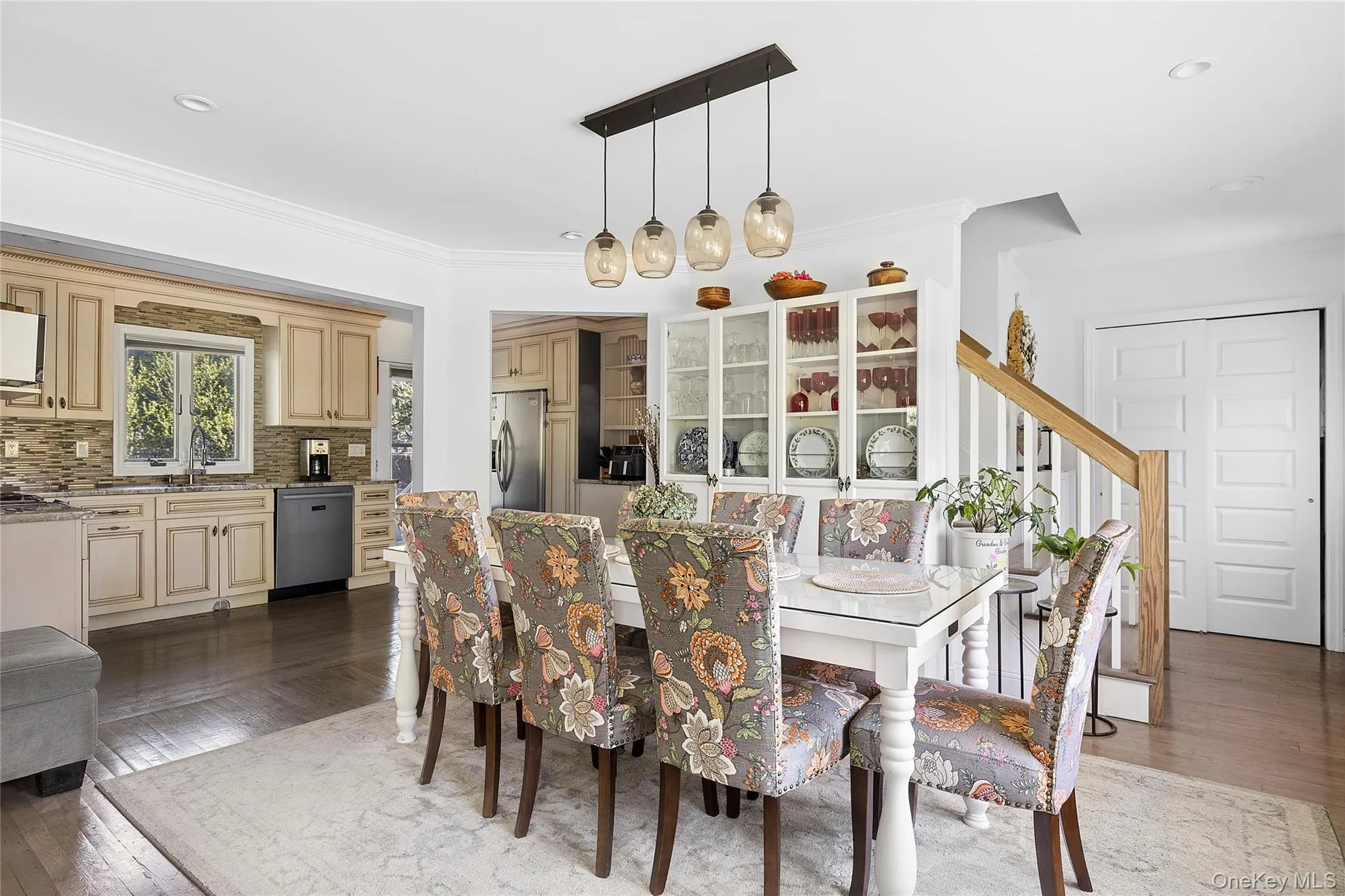 Dining area featuring a rectangular dining table, a linear pendant light fixture, and built-in display cabinetry Dining area featuring a rectangular dining table, a linear pendant light fixture, and built-in display cabinetry