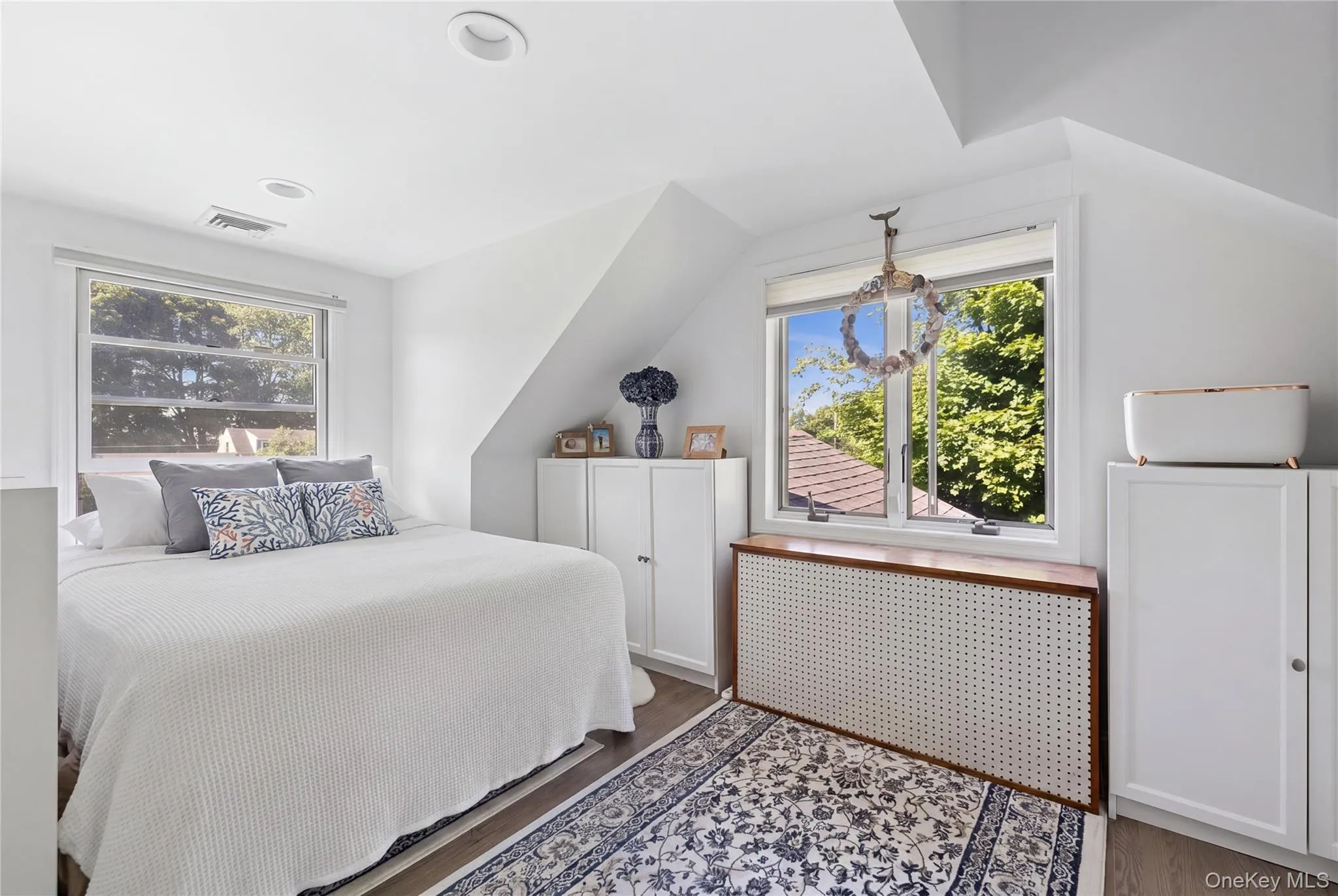 Bright bedroom featuring a sloped ceiling and recessed lighting Bright bedroom featuring a sloped ceiling and recessed lighting