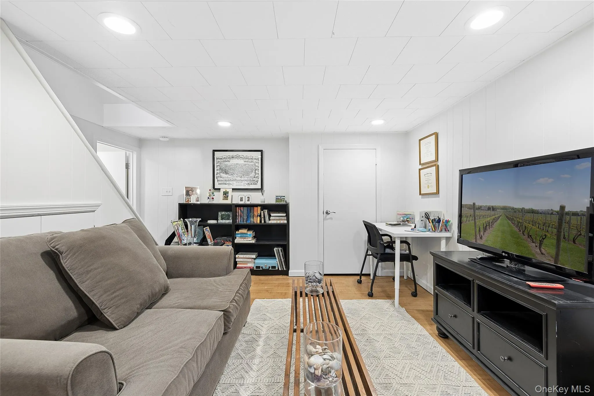 Recessed lighting illuminates this bright interior space featuring wood-finish flooring Recessed lighting illuminates this bright interior space featuring wood-finish flooring