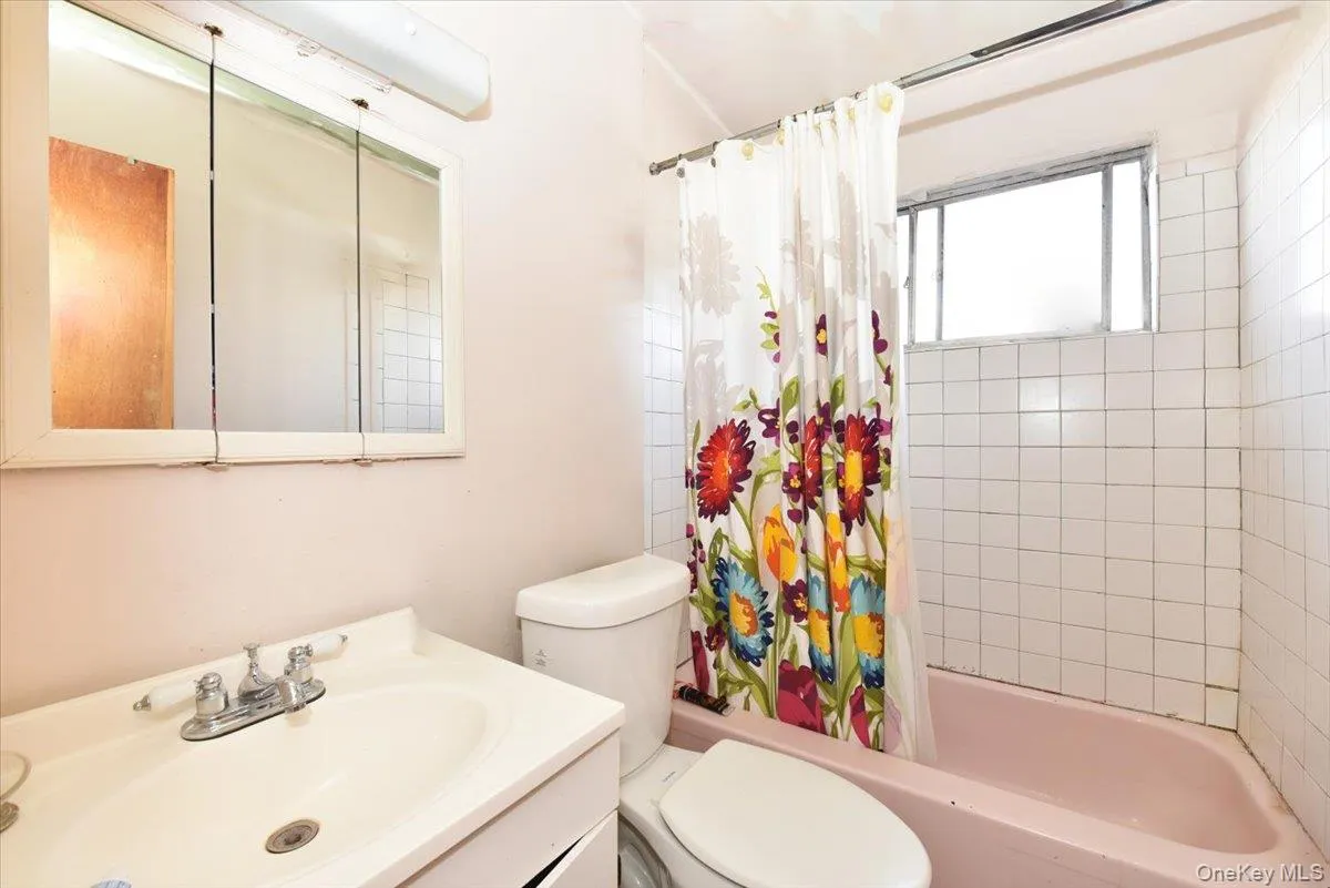 Bathroom featuring toilet, shower / bath combo, and vanity Bathroom featuring toilet, shower / bath combo, and vanity