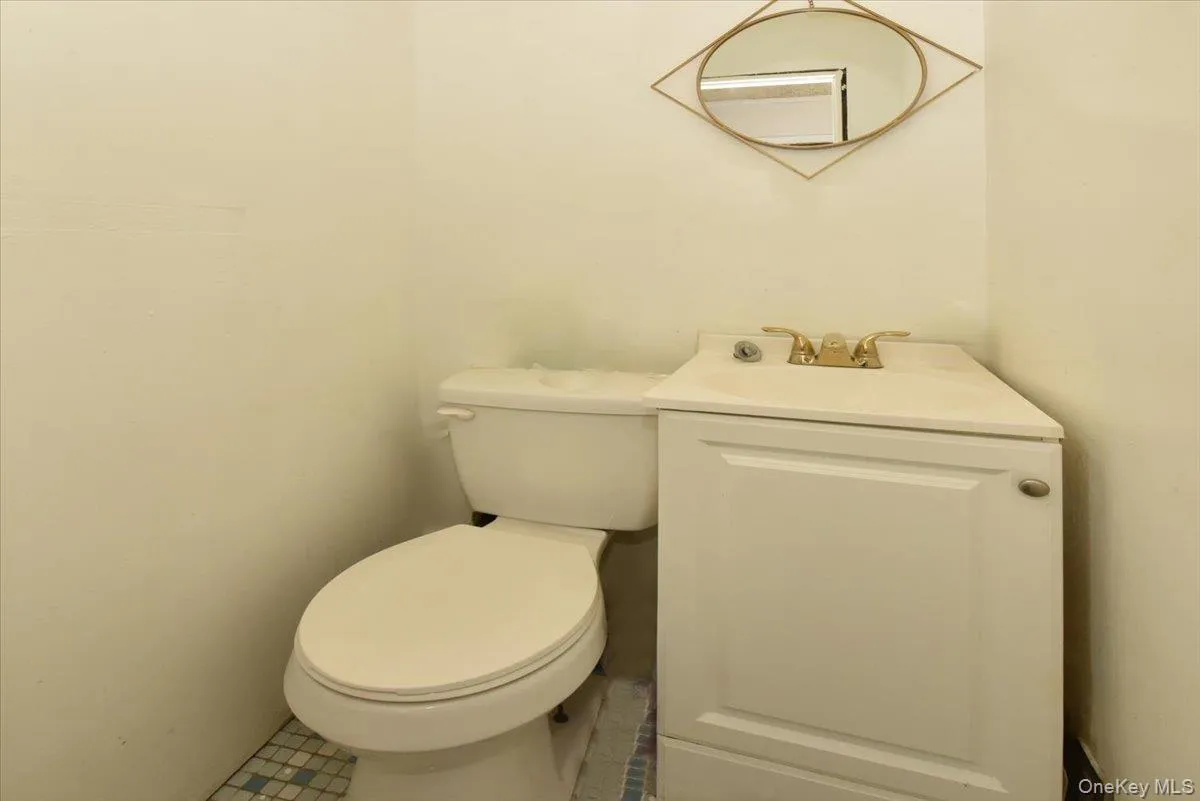 Half bath featuring toilet and vanity Half bath featuring toilet and vanity
