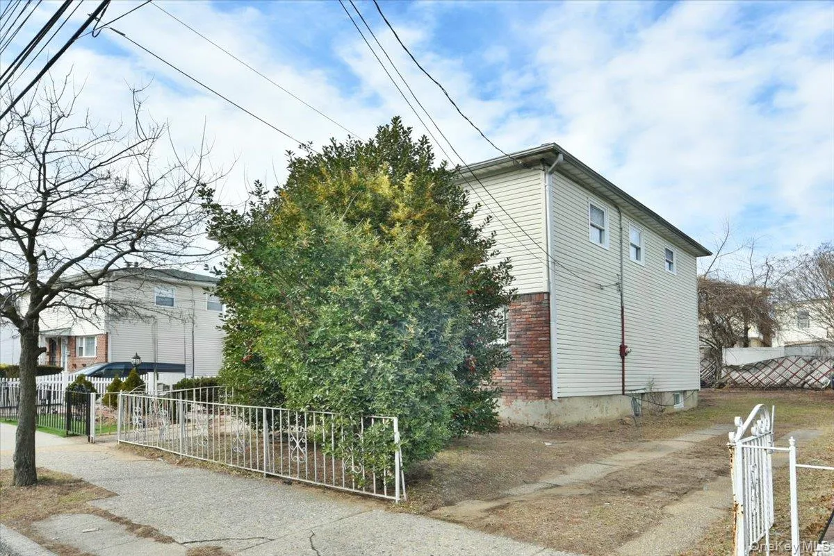 View of side of property featuring fence and brick siding View of side of property featuring fence and brick siding