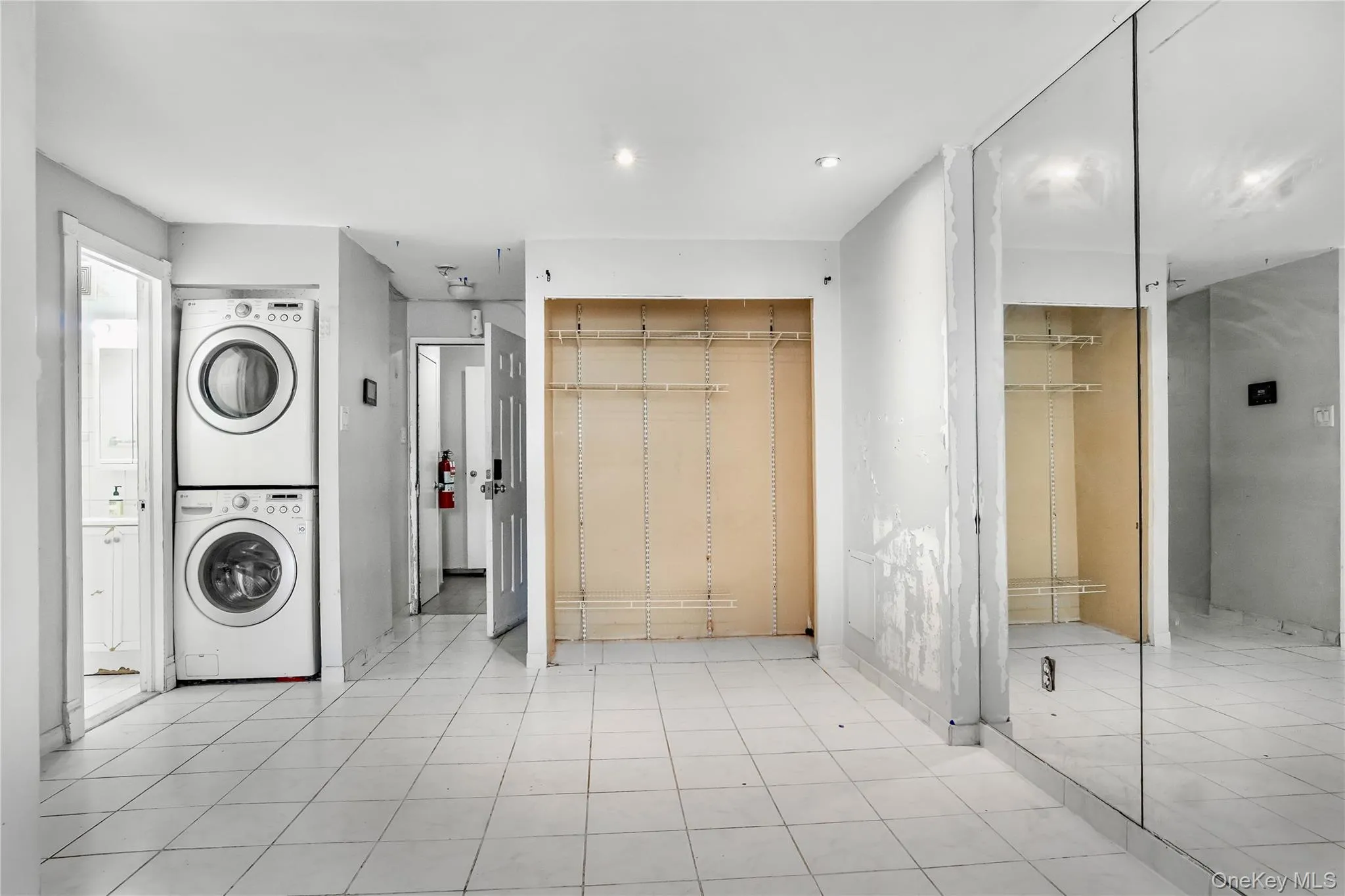 Interior space featuring white tile flooring and light-toned walls Interior space featuring white tile flooring and light-toned walls