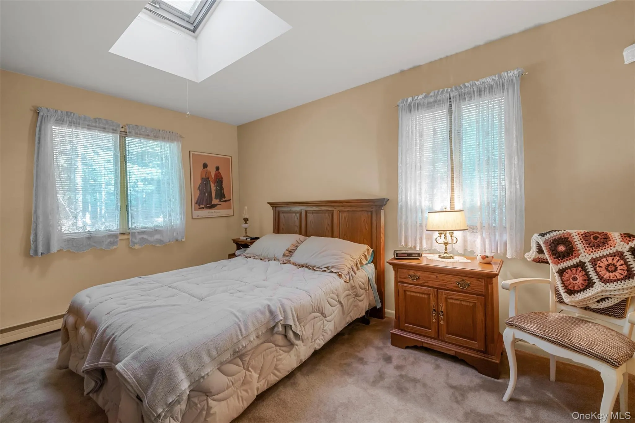 Bedroom with a skylight, multiple windows, and light carpet Bedroom with a skylight, multiple windows, and light carpet