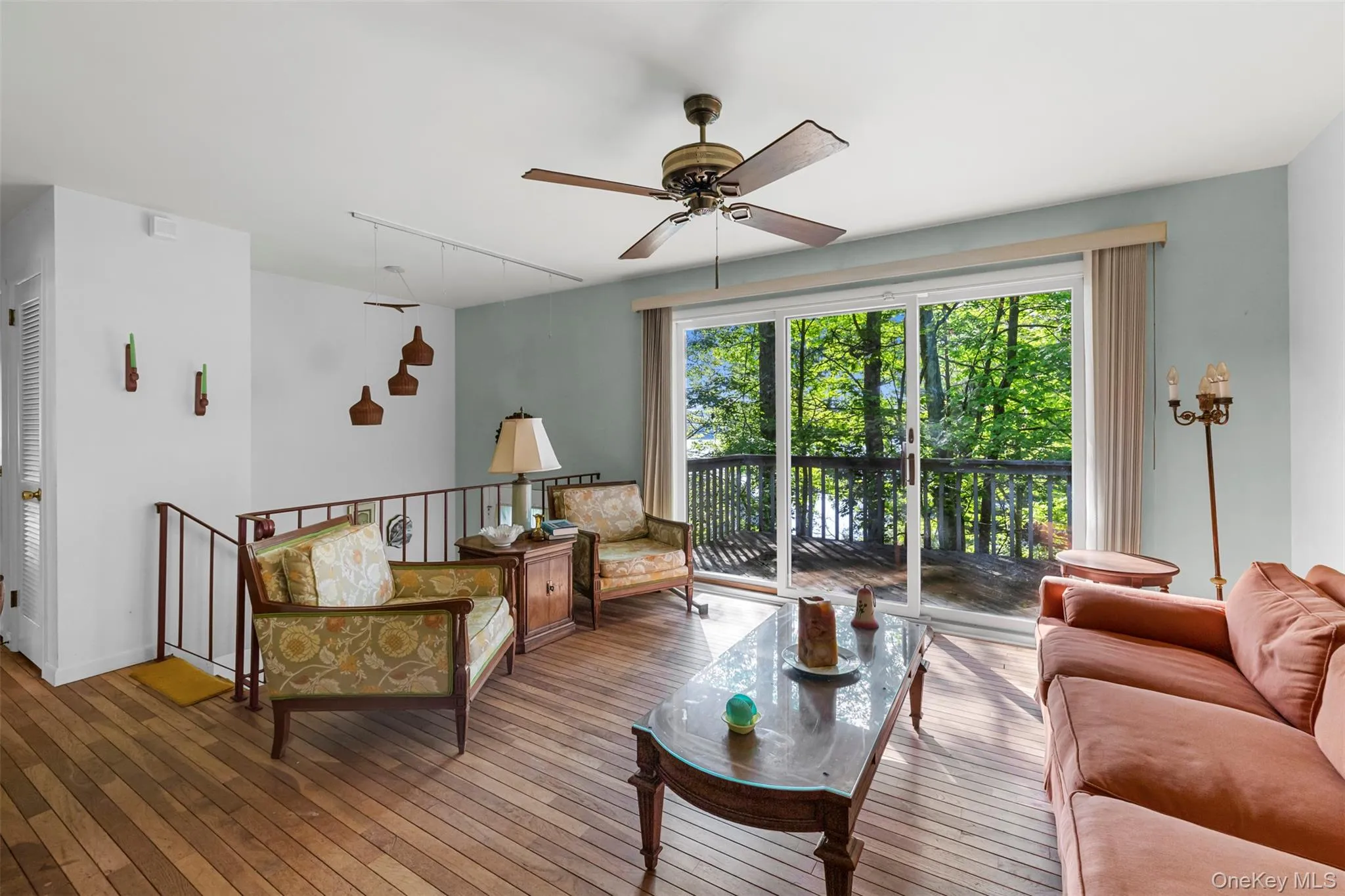 Living room with hardwood / wood-style floors, ceiling fan, and track lighting Living room with hardwood / wood-style floors, ceiling fan, and track lighting