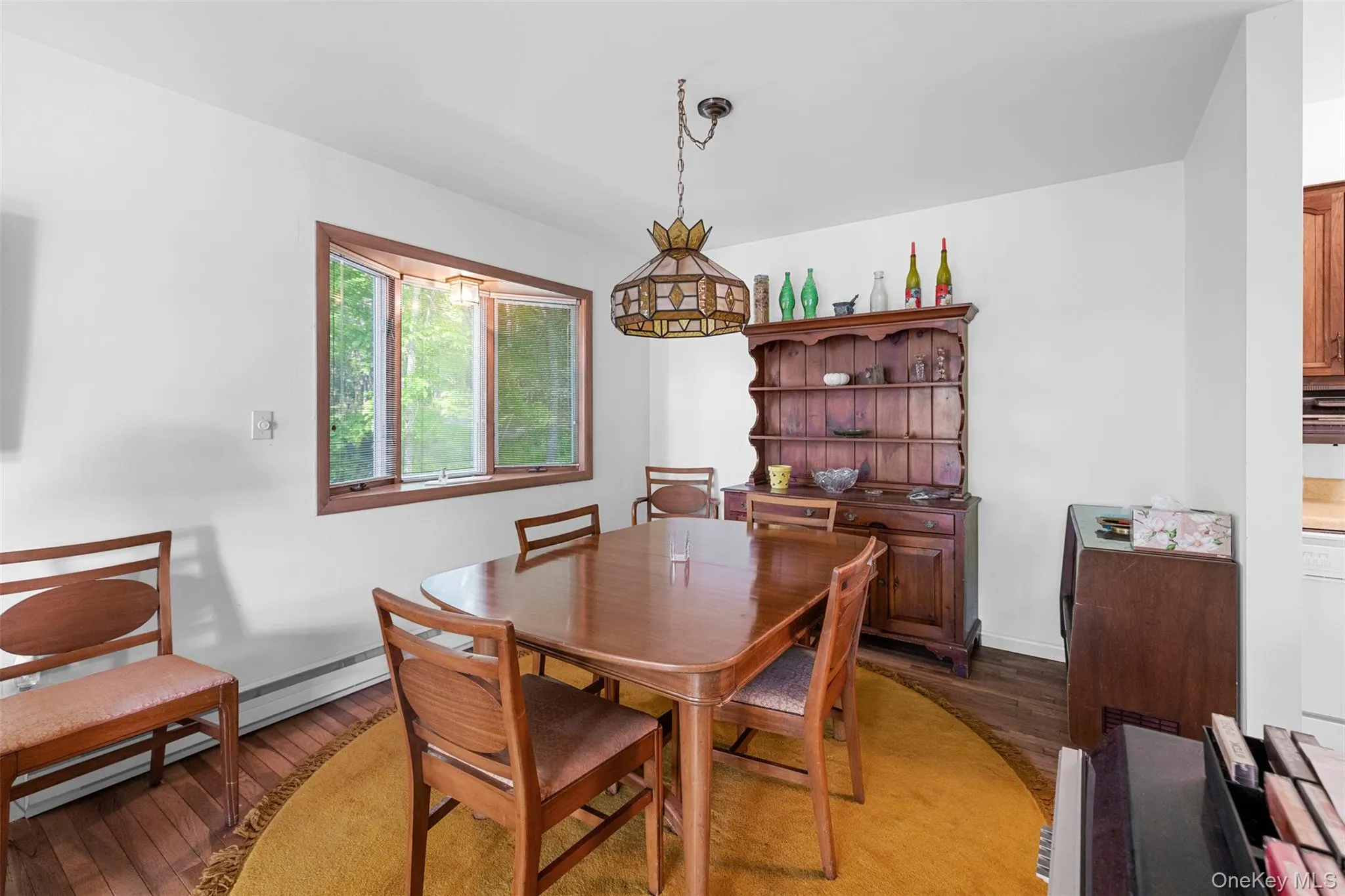 Dining space featuring light wood-style flooring, baseboards, and a baseboard radiator Dining space featuring light wood-style flooring, baseboards, and a baseboard radiator