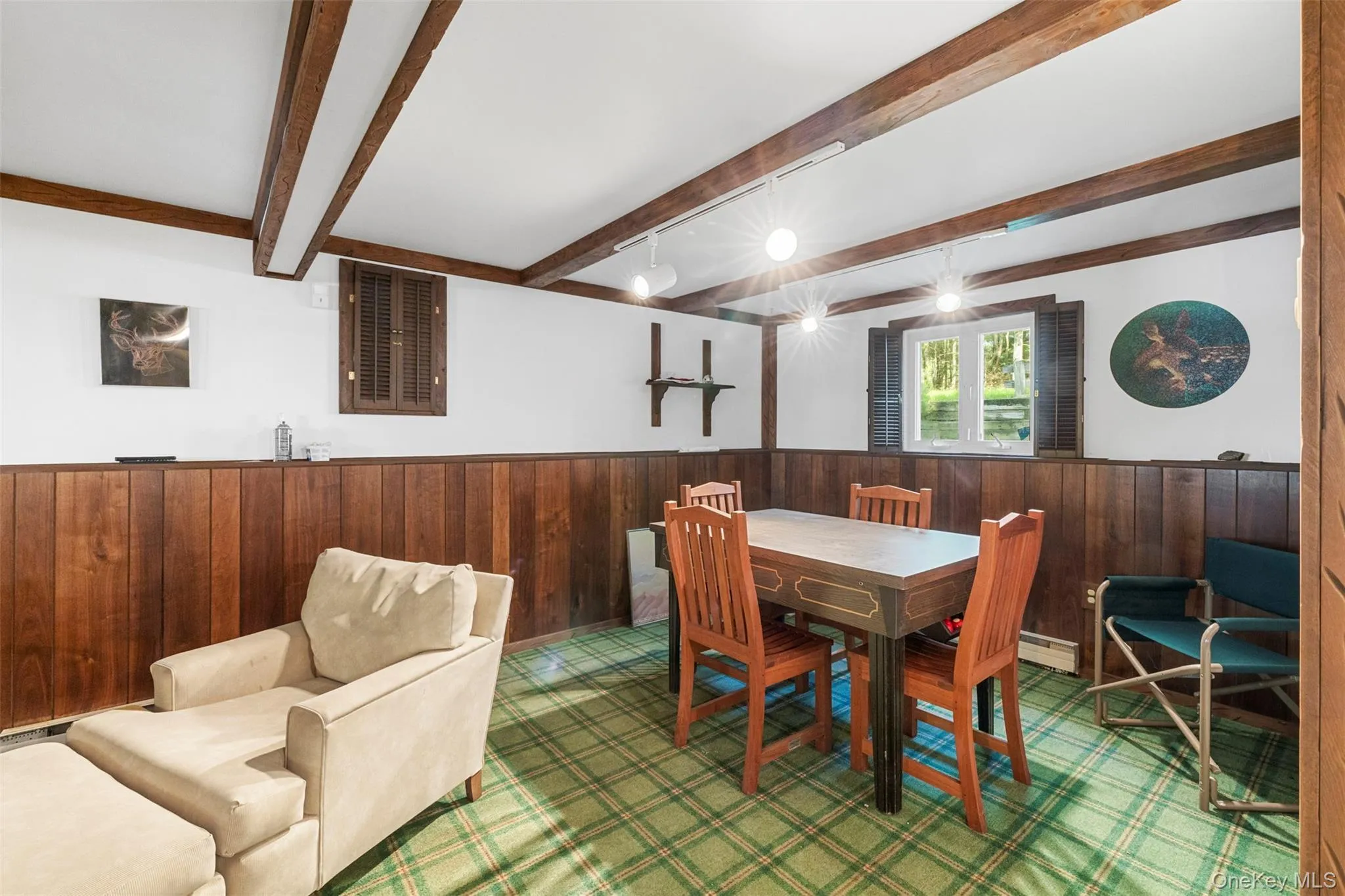 Dining room with beamed ceiling, wood walls, a wainscoted wall, and bar with sink Dining room with beamed ceiling, wood walls, a wainscoted wall, and bar with sink