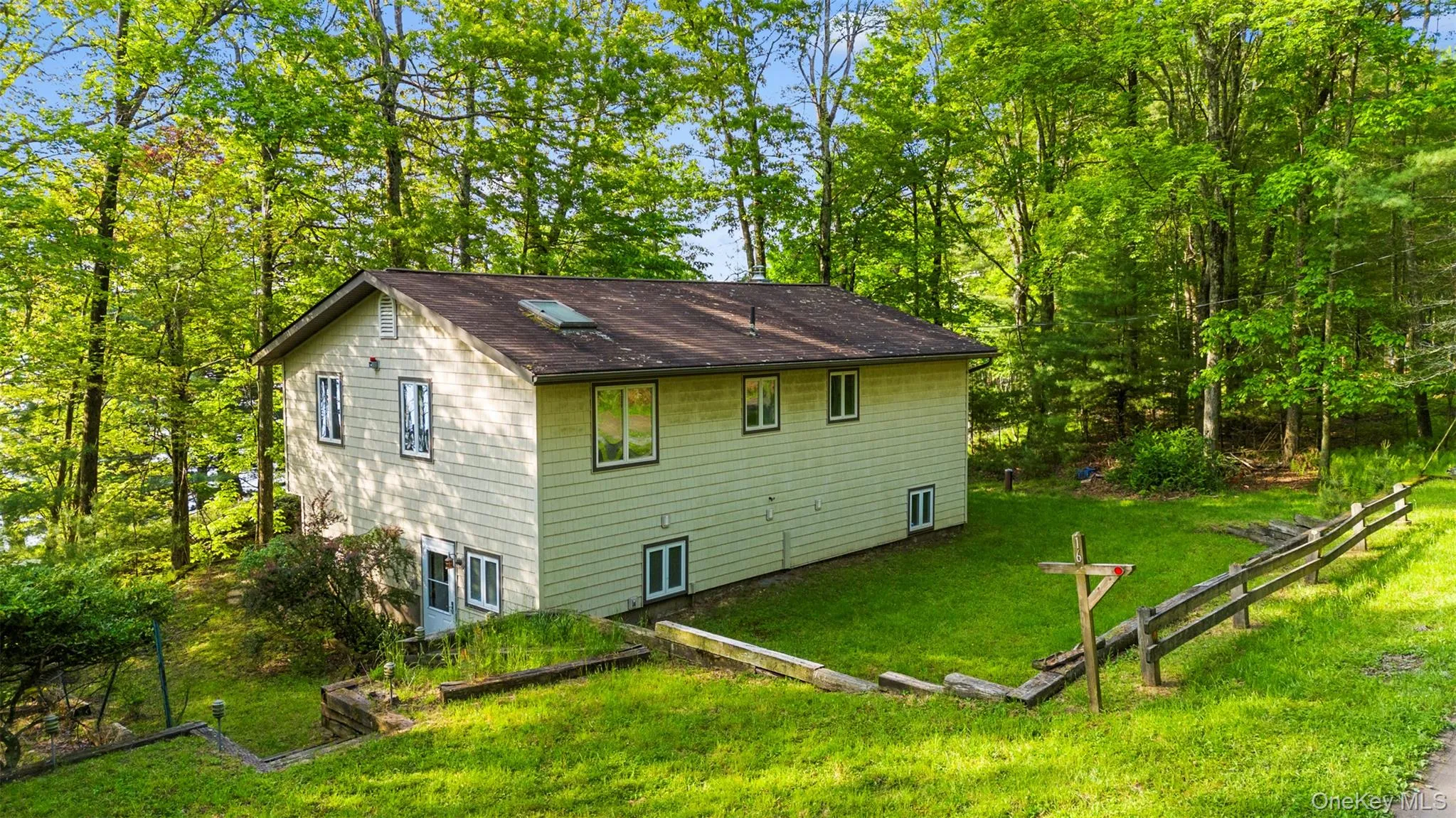 Rear view of property featuring a lawn and roof with shingles Rear view of property featuring a lawn and roof with shingles