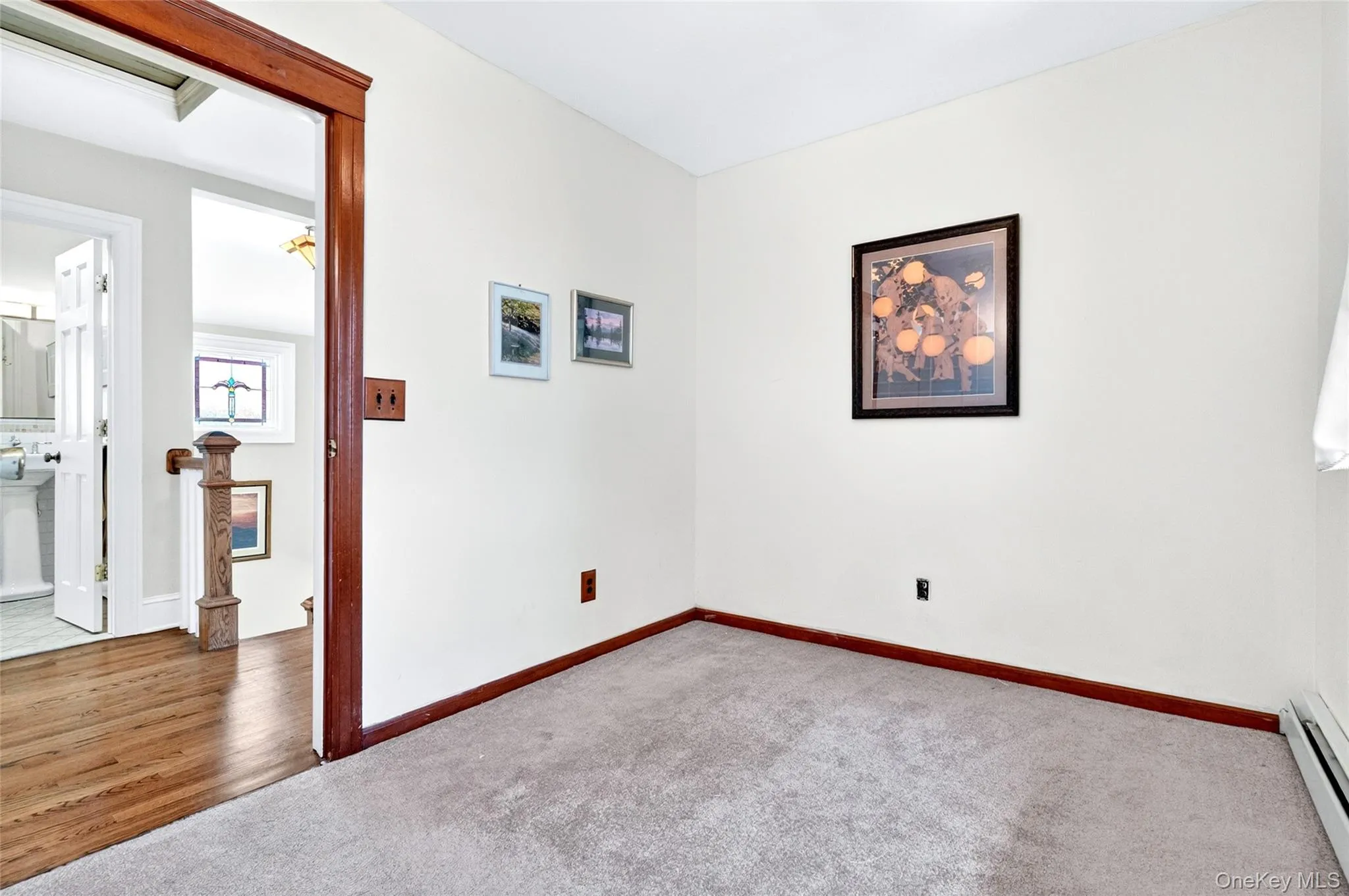 Carpeted room with a wide wood-trimmed doorway Carpeted room with a wide wood-trimmed doorway