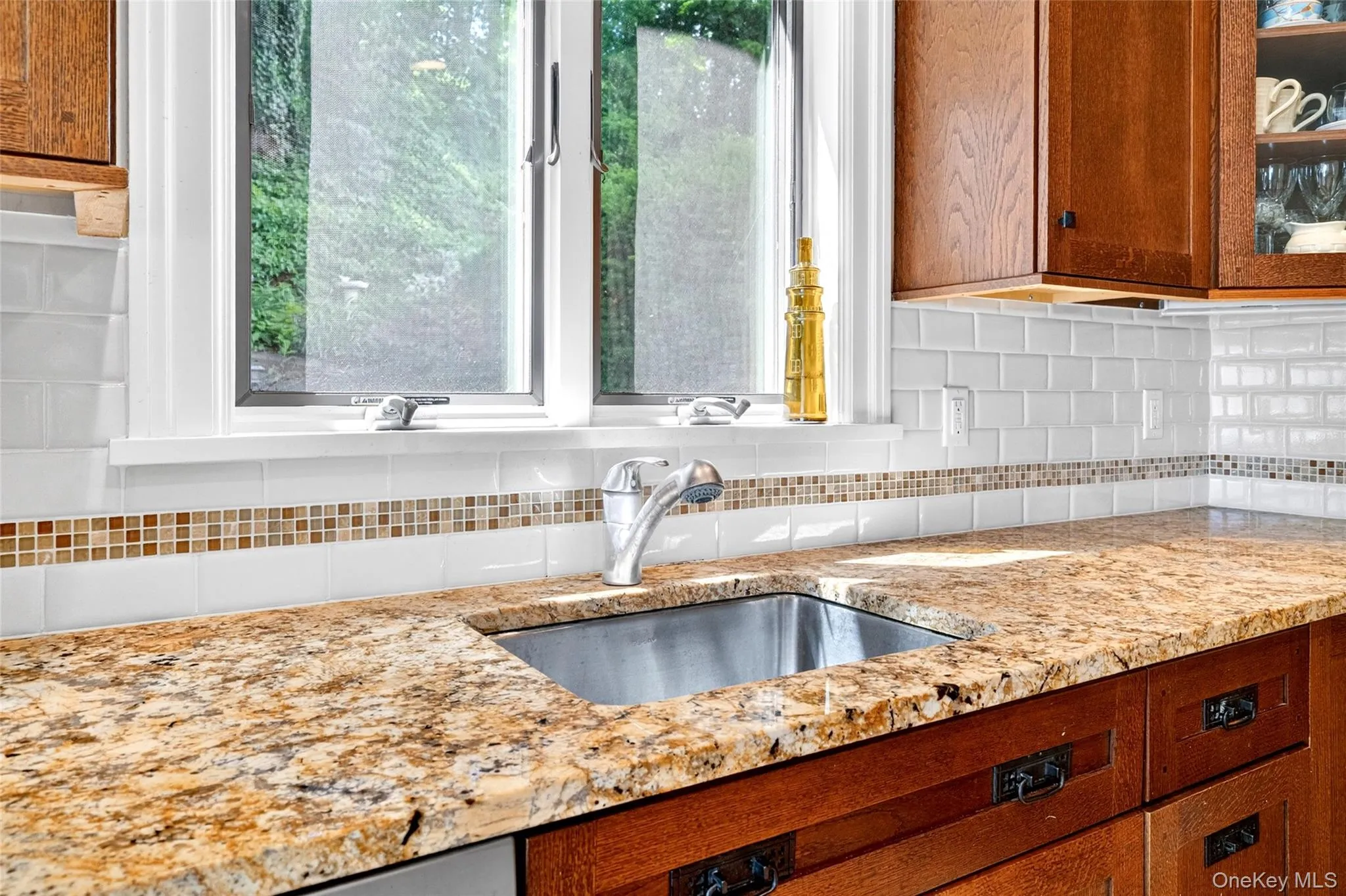 Stainless steel undermount sink with a gooseneck faucet, set within granite countertops Stainless steel undermount sink with a gooseneck faucet, set within granite countertops