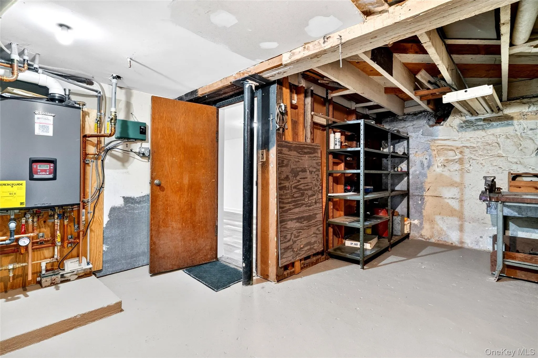 Utility area featuring a boiler system with copper piping, an exposed wooden beam ceiling, and a concrete floor Utility area featuring a boiler system with copper piping, an exposed wooden beam ceiling, and a concrete floor