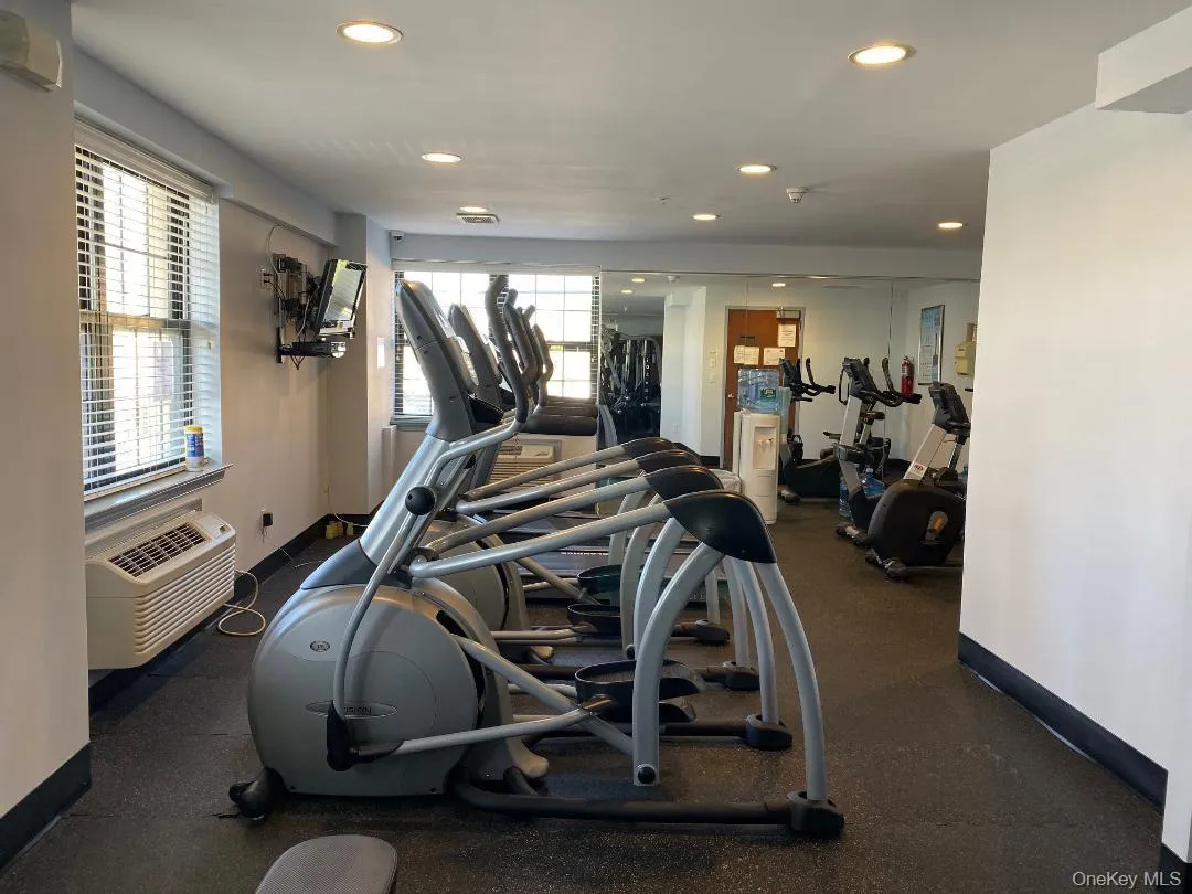 Workout area featuring a wealth of natural light, a wall unit AC, baseboards, and recessed lighting Workout area featuring a wealth of natural light, a wall unit AC, baseboards, and recessed lighting