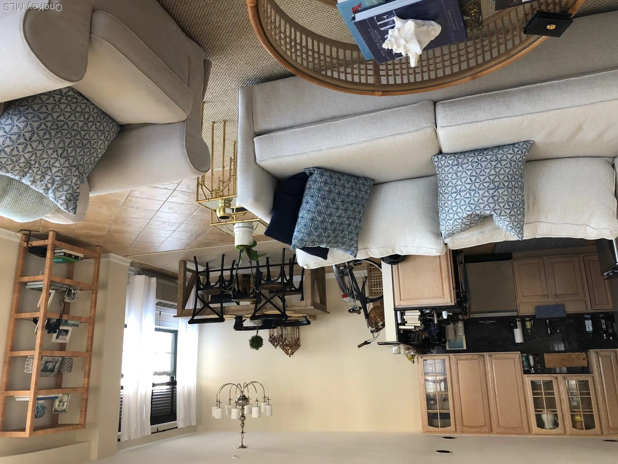 Living room featuring light tile patterned floors, baseboards, and a notable chandelier Living room featuring light tile patterned floors, baseboards, and a notable chandelier