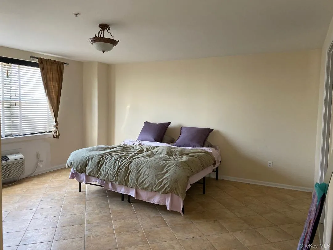 Bedroom with light tile patterned floors and baseboards Bedroom with light tile patterned floors and baseboards