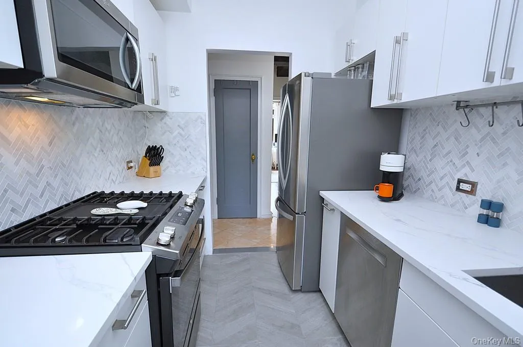 The thoughtfully renovated kitchen is a chef’s delight, showcasing stainless steel appliances, custom white cabinetry, abundant quartz countertops, and generous workspace. The thoughtfully renovated kitchen is a chef’s delight, showcasing stainless steel appliances, custom white cabinetry, abundant quartz countertops, and generous workspace.