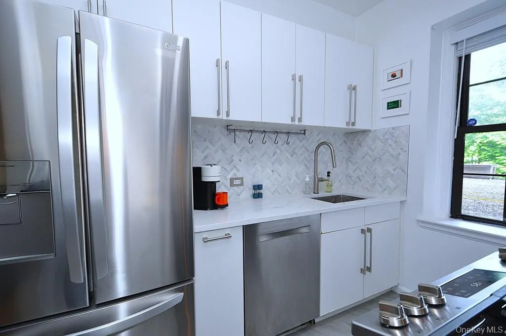 The thoughtfully renovated kitchen is a chef’s delight, showcasing stainless steel appliances, custom white cabinetry, abundant quartz countertops, and generous workspace. The thoughtfully renovated kitchen is a chef’s delight, showcasing stainless steel appliances, custom white cabinetry, abundant quartz countertops, and generous workspace.