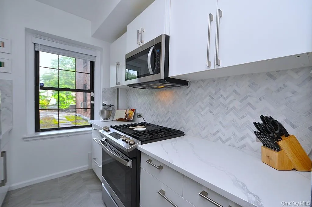 The thoughtfully renovated kitchen is a chef’s delight, showcasing stainless steel appliances, custom white cabinetry, abundant quartz countertops, and generous workspace. The thoughtfully renovated kitchen is a chef’s delight, showcasing stainless steel appliances, custom white cabinetry, abundant quartz countertops, and generous workspace.