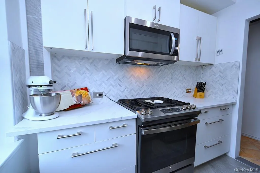The thoughtfully renovated kitchen is a chef’s delight, showcasing stainless steel appliances, custom white cabinetry, abundant quartz countertops, and generous workspace. The thoughtfully renovated kitchen is a chef’s delight, showcasing stainless steel appliances, custom white cabinetry, abundant quartz countertops, and generous workspace.
