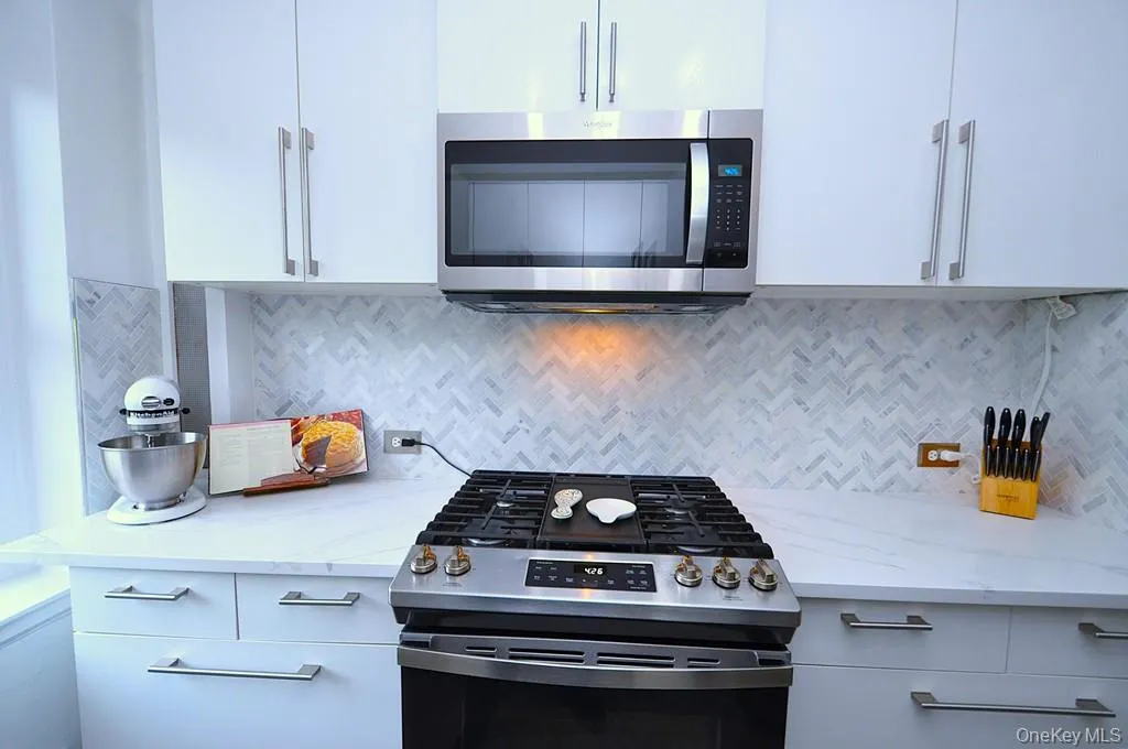 The thoughtfully renovated kitchen is a chef’s delight, showcasing stainless steel appliances, custom white cabinetry, abundant quartz countertops, and generous workspace. The thoughtfully renovated kitchen is a chef’s delight, showcasing stainless steel appliances, custom white cabinetry, abundant quartz countertops, and generous workspace.