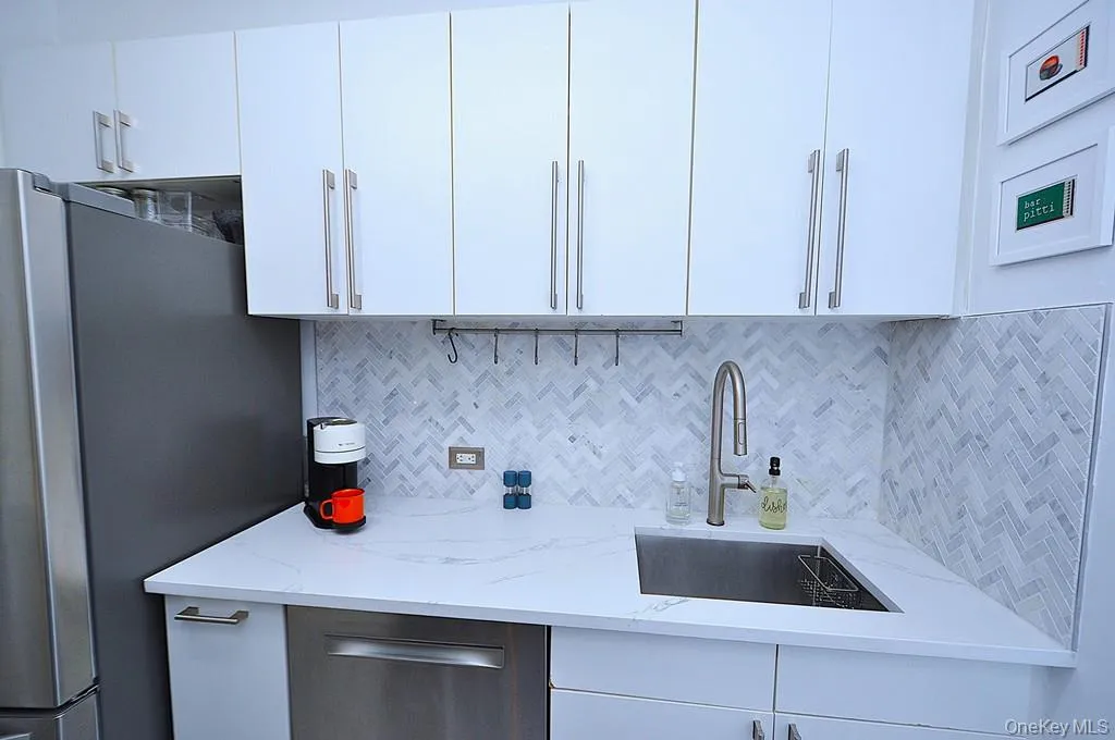 The thoughtfully renovated kitchen is a chef’s delight, showcasing stainless steel appliances, custom white cabinetry, abundant quartz countertops, and generous workspace. The thoughtfully renovated kitchen is a chef’s delight, showcasing stainless steel appliances, custom white cabinetry, abundant quartz countertops, and generous workspace.
