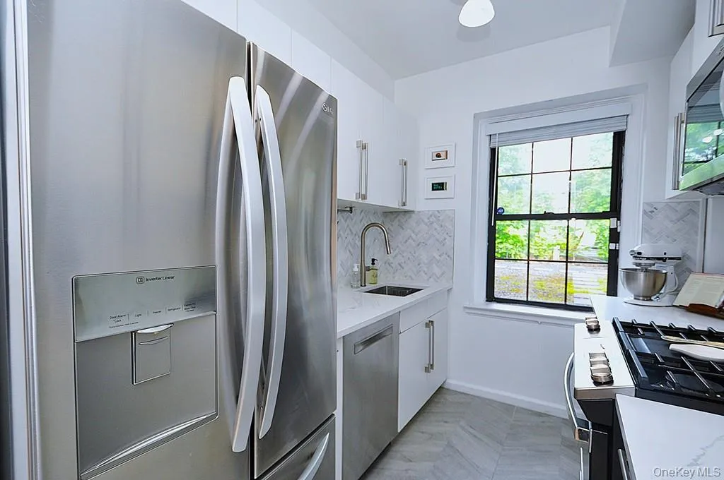 The thoughtfully renovated kitchen is a chef’s delight, showcasing stainless steel appliances, custom white cabinetry, abundant quartz countertops, and generous workspace. The thoughtfully renovated kitchen is a chef’s delight, showcasing stainless steel appliances, custom white cabinetry, abundant quartz countertops, and generous workspace.