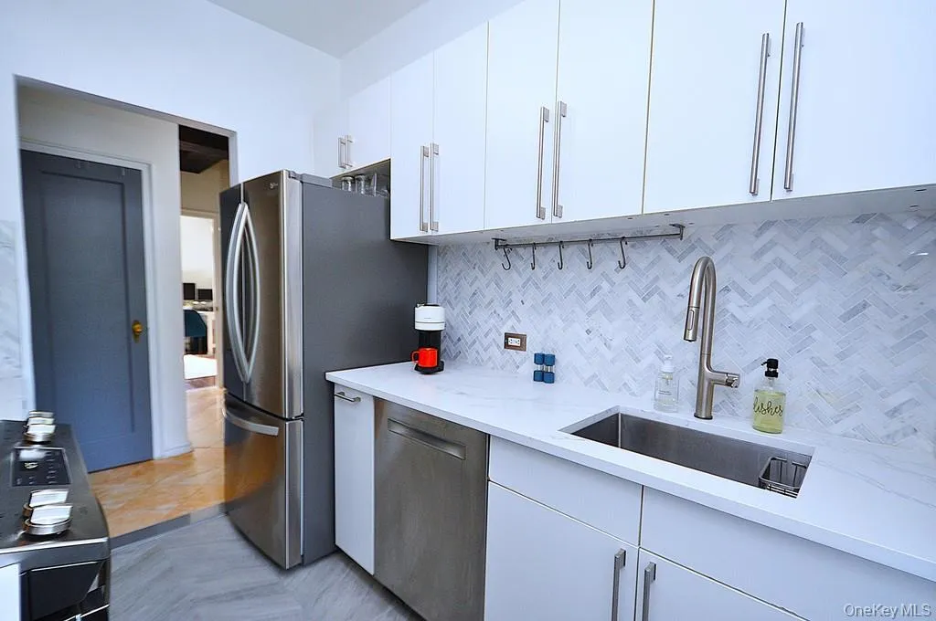 The thoughtfully renovated kitchen is a chef’s delight, showcasing stainless steel appliances, custom white cabinetry, abundant quartz countertops, and generous workspace. The thoughtfully renovated kitchen is a chef’s delight, showcasing stainless steel appliances, custom white cabinetry, abundant quartz countertops, and generous workspace.