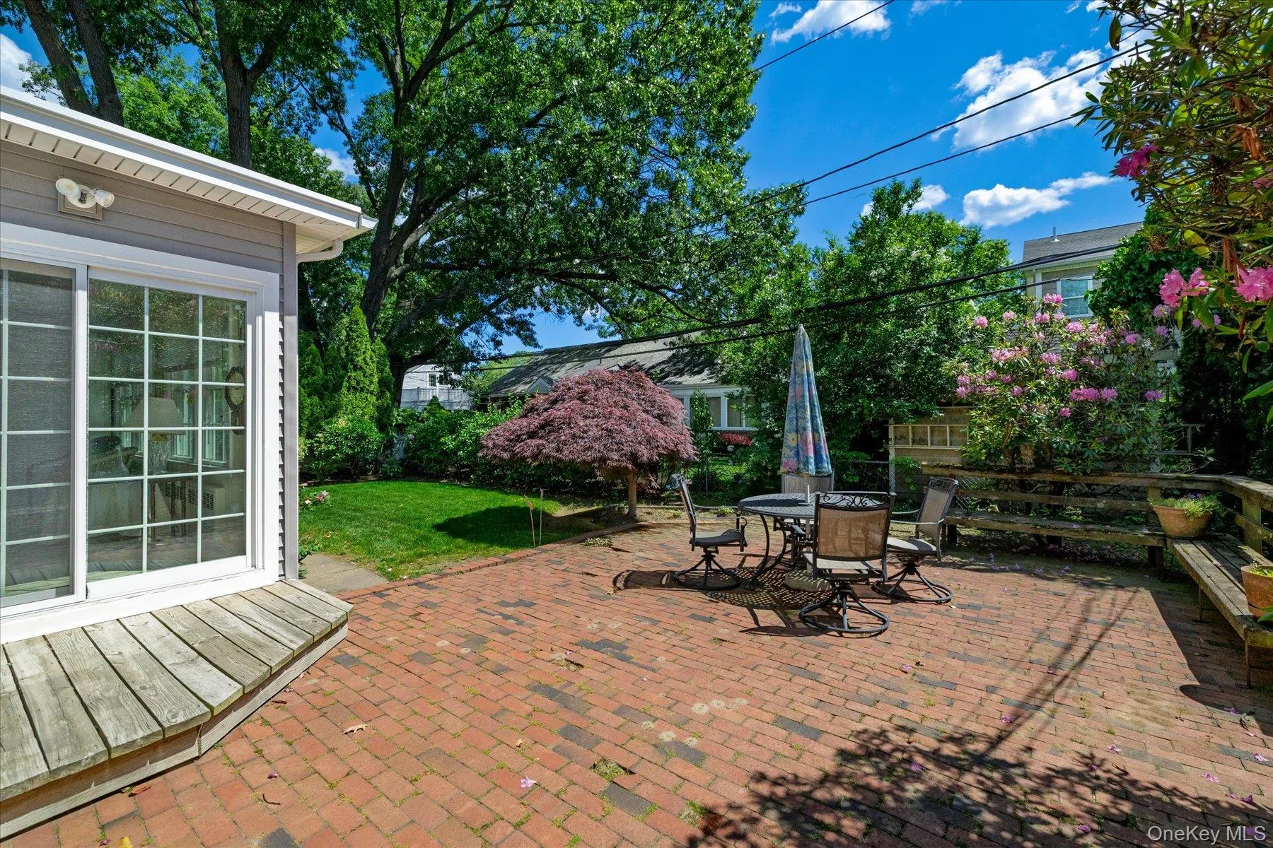 Brick paver patio with an adjacent wooden deck. Brick paver patio with an adjacent wooden deck.