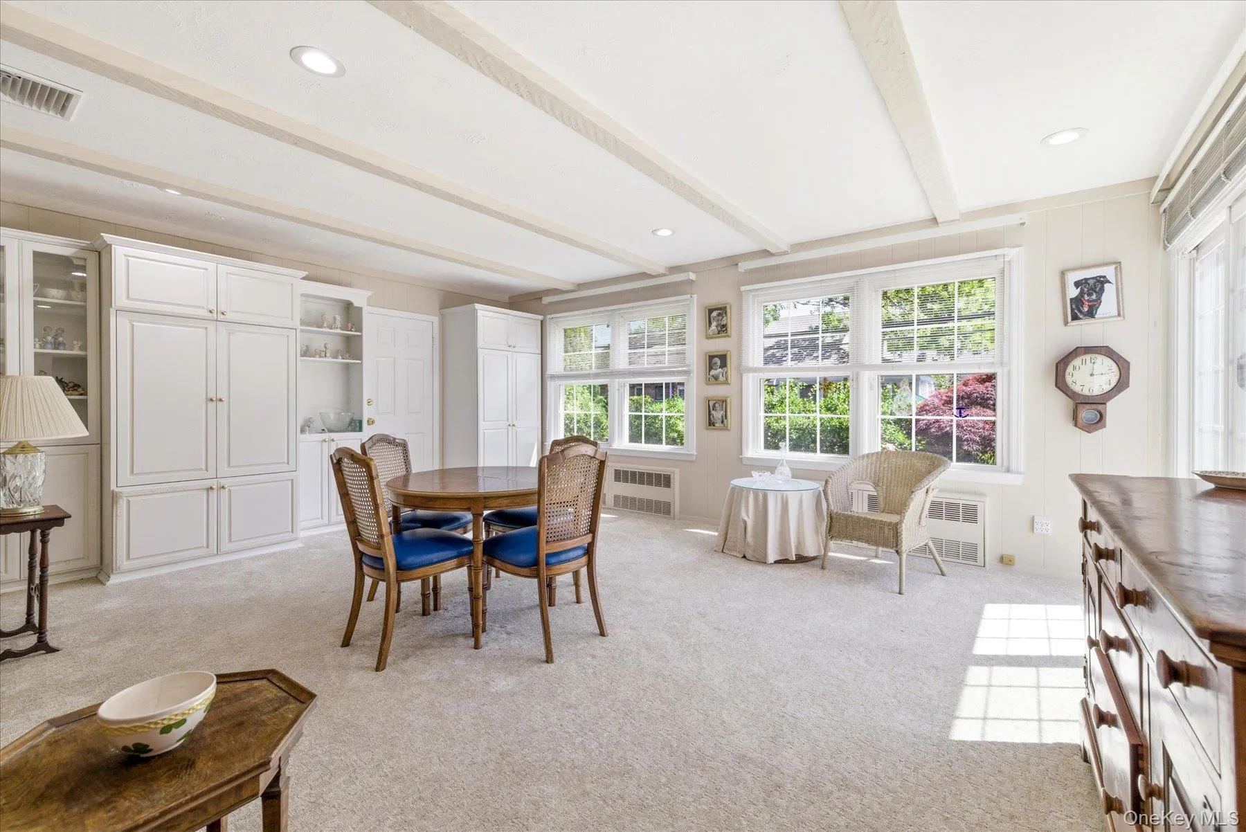 Room featuring coffered ceilings with recessed lighting, extensive built-in cabinetry, carpeted flooring, and multiple double-hung windows. Room featuring coffered ceilings with recessed lighting, extensive built-in cabinetry, carpeted flooring, and multiple double-hung windows.