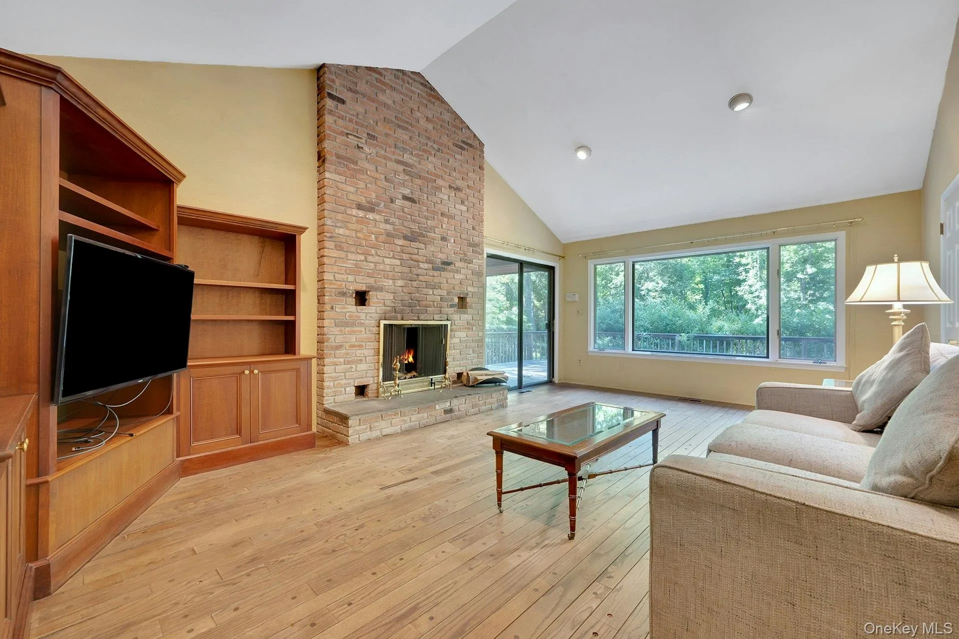 Inviting family room with cathedral ceiling, fireplace and access to yard. Inviting family room with cathedral ceiling, fireplace and access to yard.