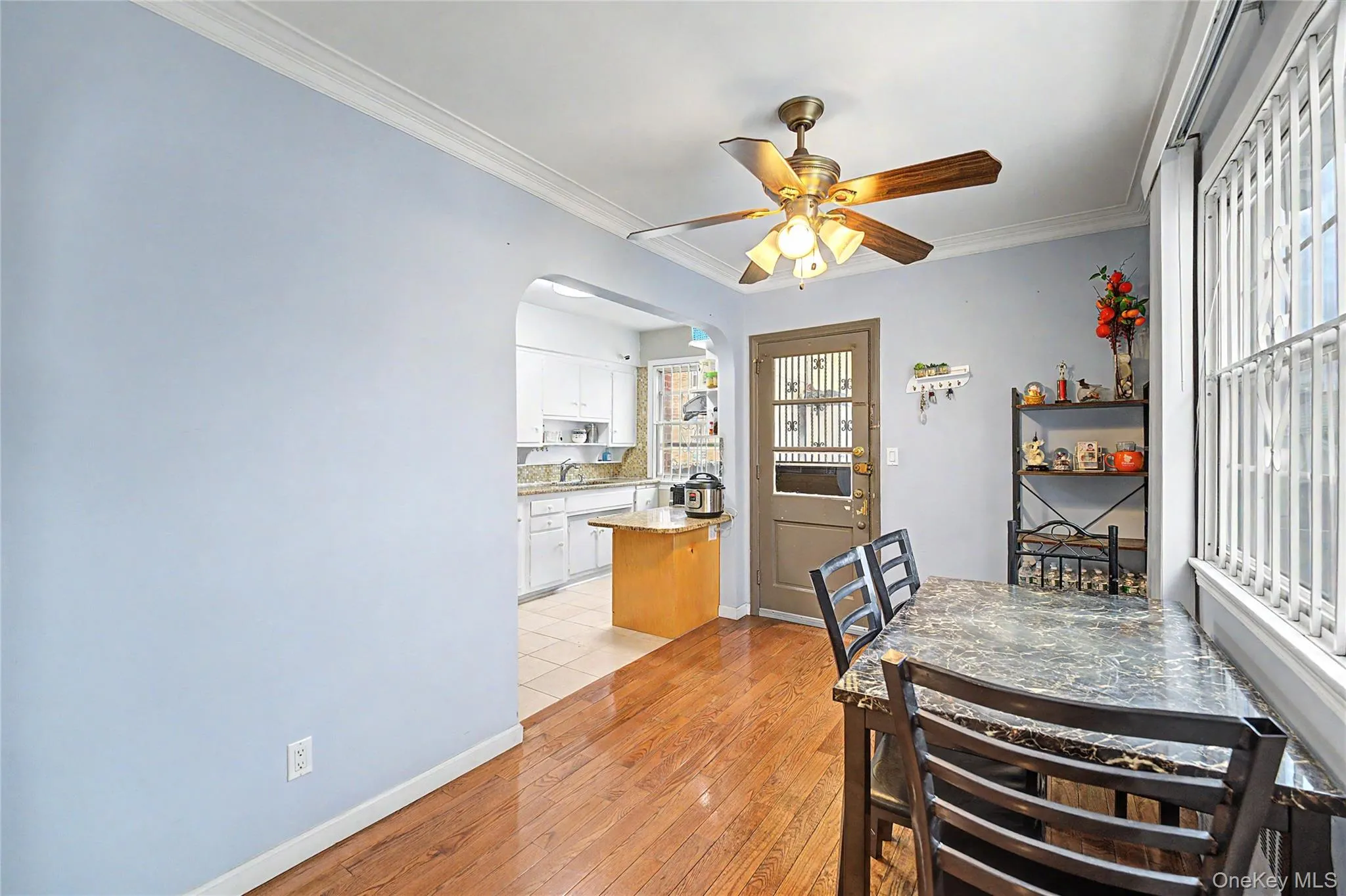 Dining area featuring wood-finish flooring, crown molding, and a ceiling fan Dining area featuring wood-finish flooring, crown molding, and a ceiling fan