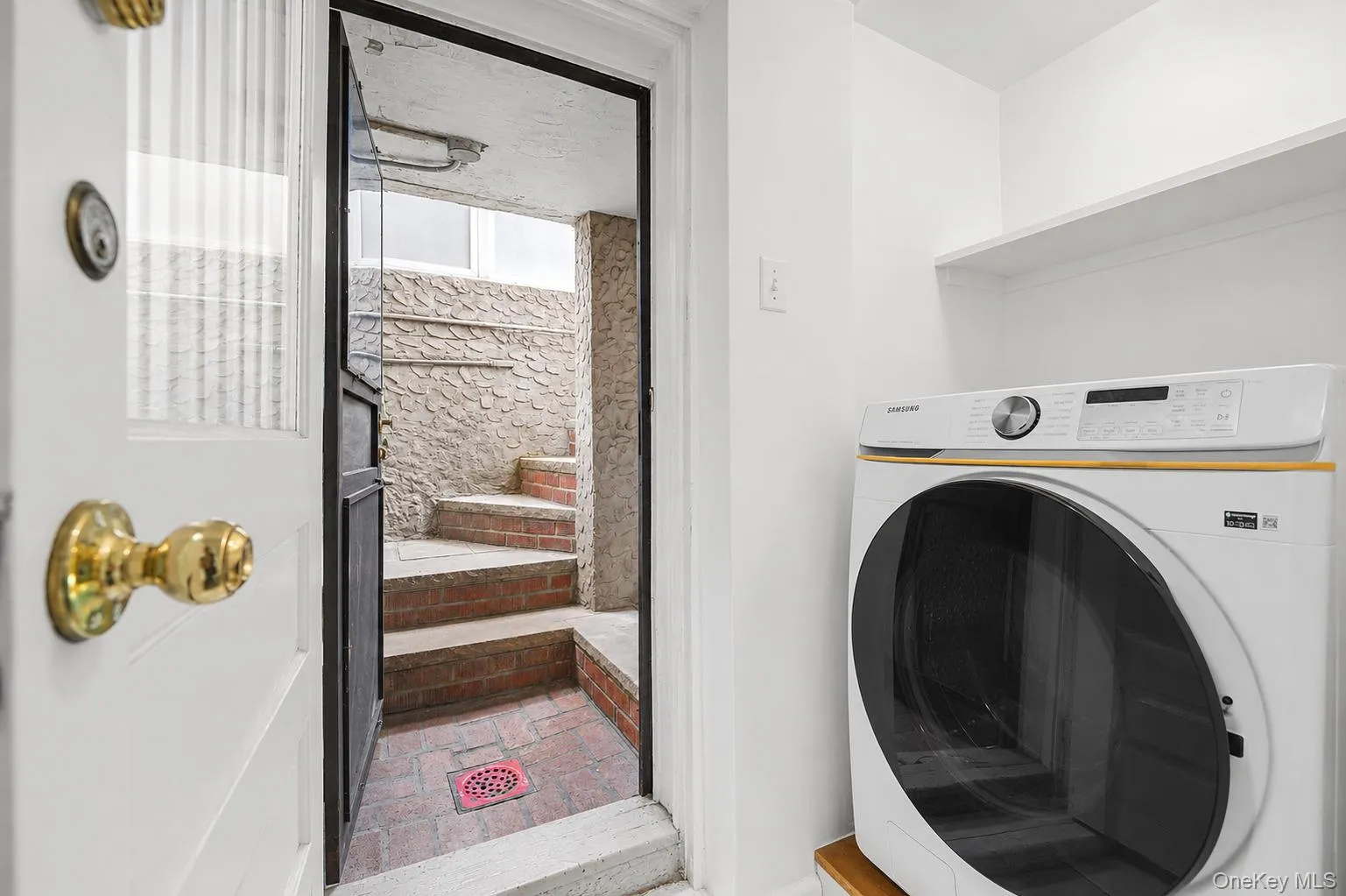 Dedicated laundry area featuring a built-in shelf for storage Dedicated laundry area featuring a built-in shelf for storage