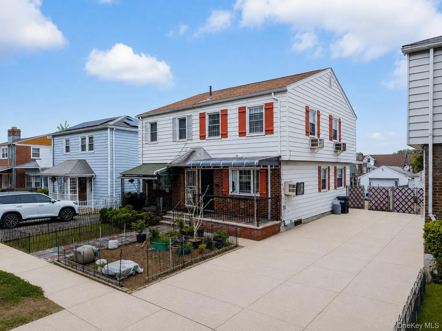 Two-story residence featuring white siding and contrasting red shutters Two-story residence featuring white siding and contrasting red shutters