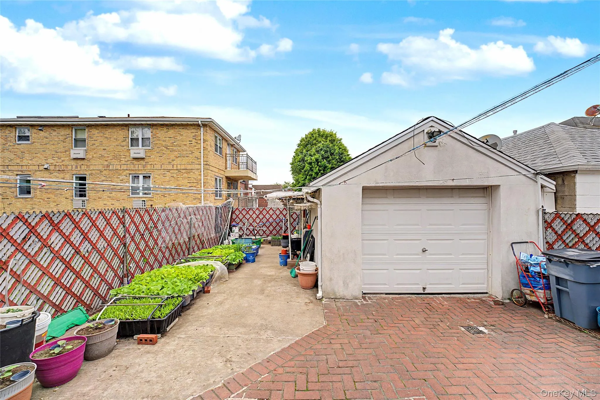 Detached garage with a paneled door, offering paved brick-patterned hardscaping Detached garage with a paneled door, offering paved brick-patterned hardscaping