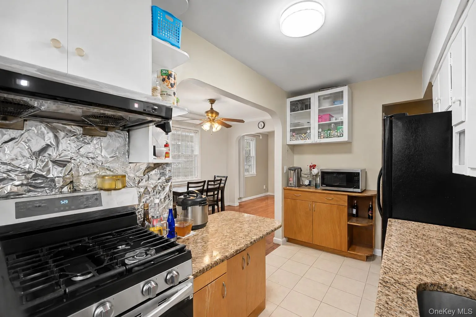 Kitchen featuring light-toned cabinetry, granite-style countertops, and tiled flooring Kitchen featuring light-toned cabinetry, granite-style countertops, and tiled flooring