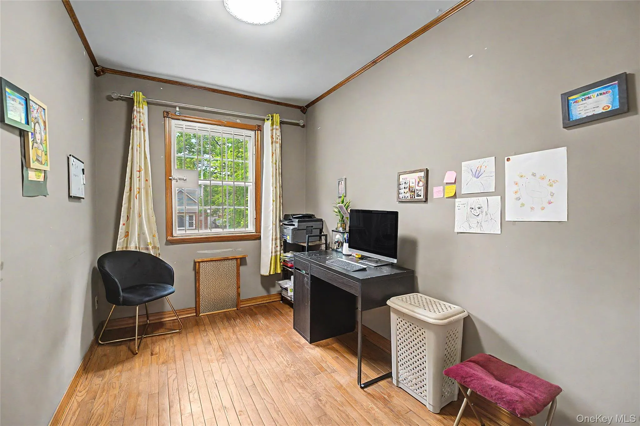 Room featuring wood-finish flooring, a window with natural light, and crown molding Room featuring wood-finish flooring, a window with natural light, and crown molding