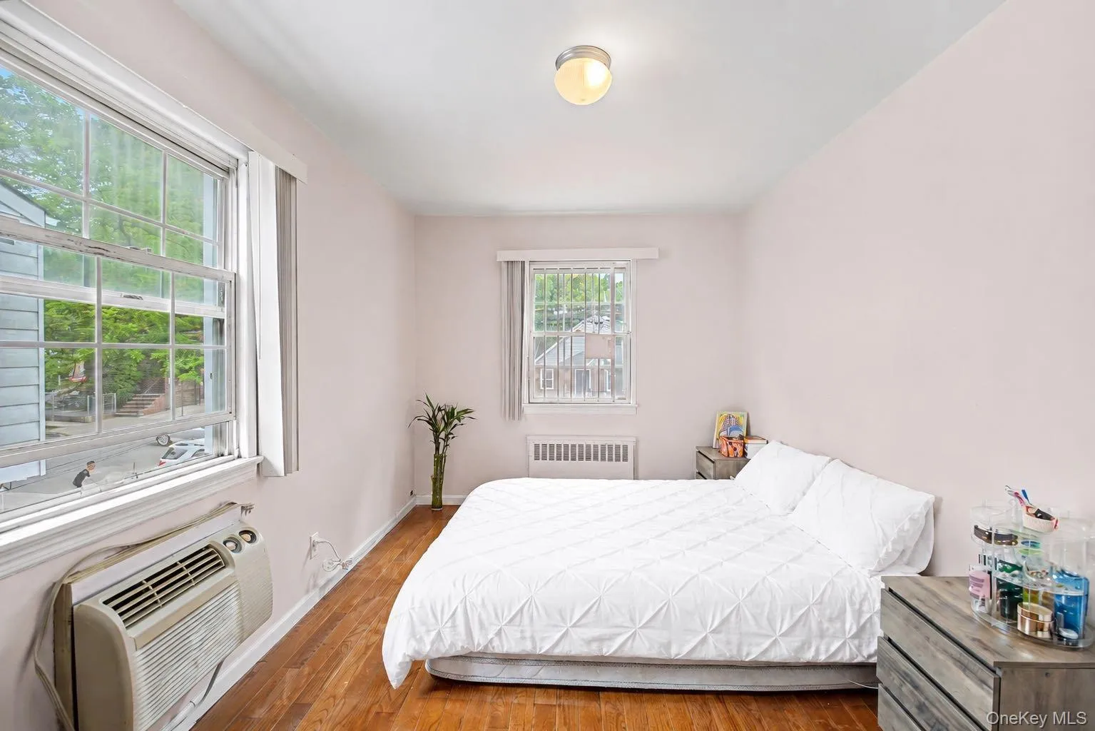Room featuring wood-finish flooring, light-toned walls, and multiple windows Room featuring wood-finish flooring, light-toned walls, and multiple windows