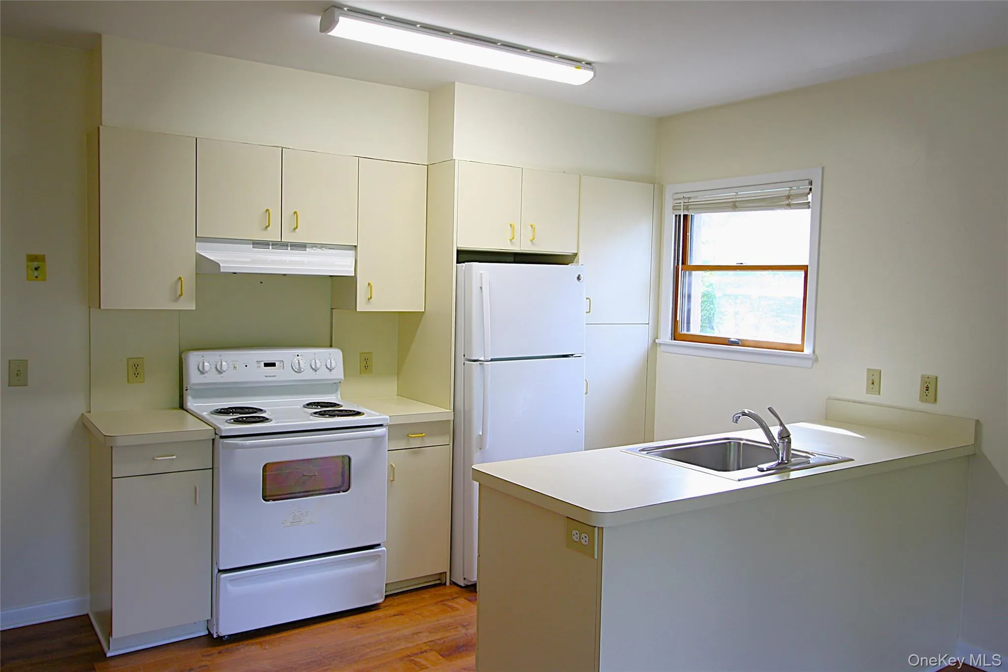 The kitchen has plenty of natural light from the window on the right, as well as good cabinet space and an efficient layout. The kitchen has plenty of natural light from the window on the right, as well as good cabinet space and an efficient layout.