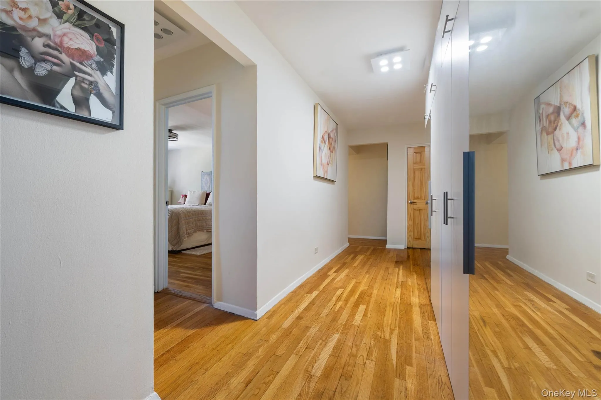 Hardwood flooring extending through a hallway with white walls Hardwood flooring extending through a hallway with white walls