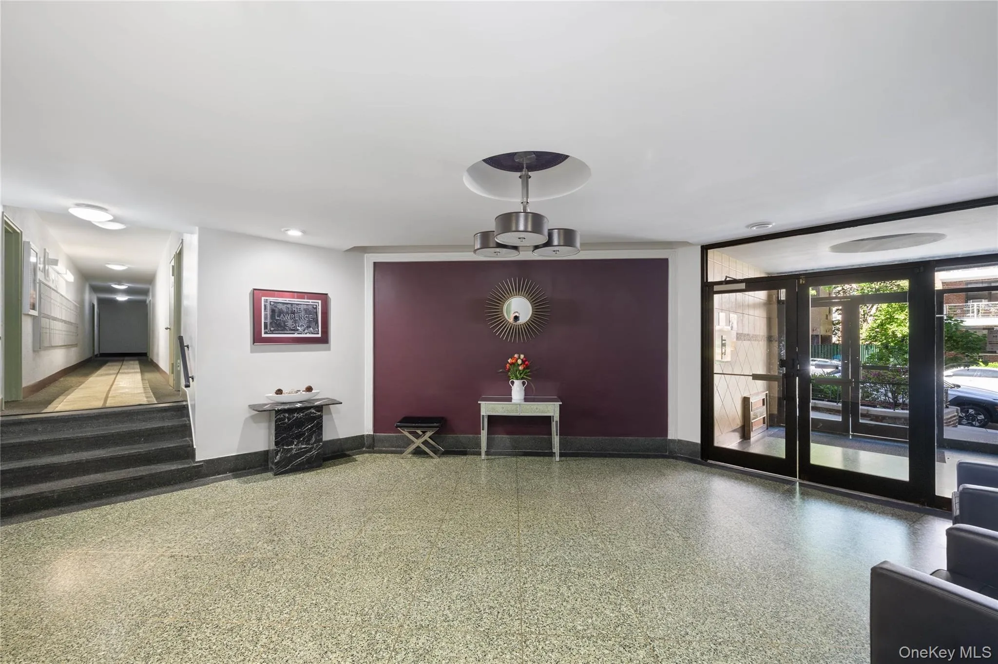 Lobby featuring terrazzo flooring and a modern chandelier Lobby featuring terrazzo flooring and a modern chandelier