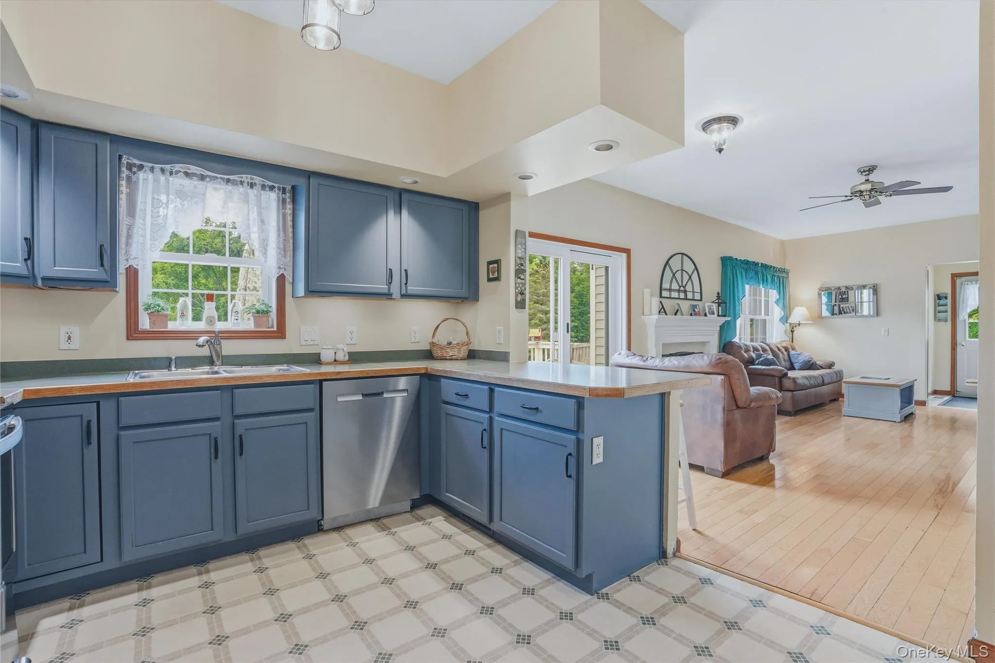 Open kitchen to living room with fireplace and wood floors and sliding glass door Open kitchen to living room with fireplace and wood floors and sliding glass door