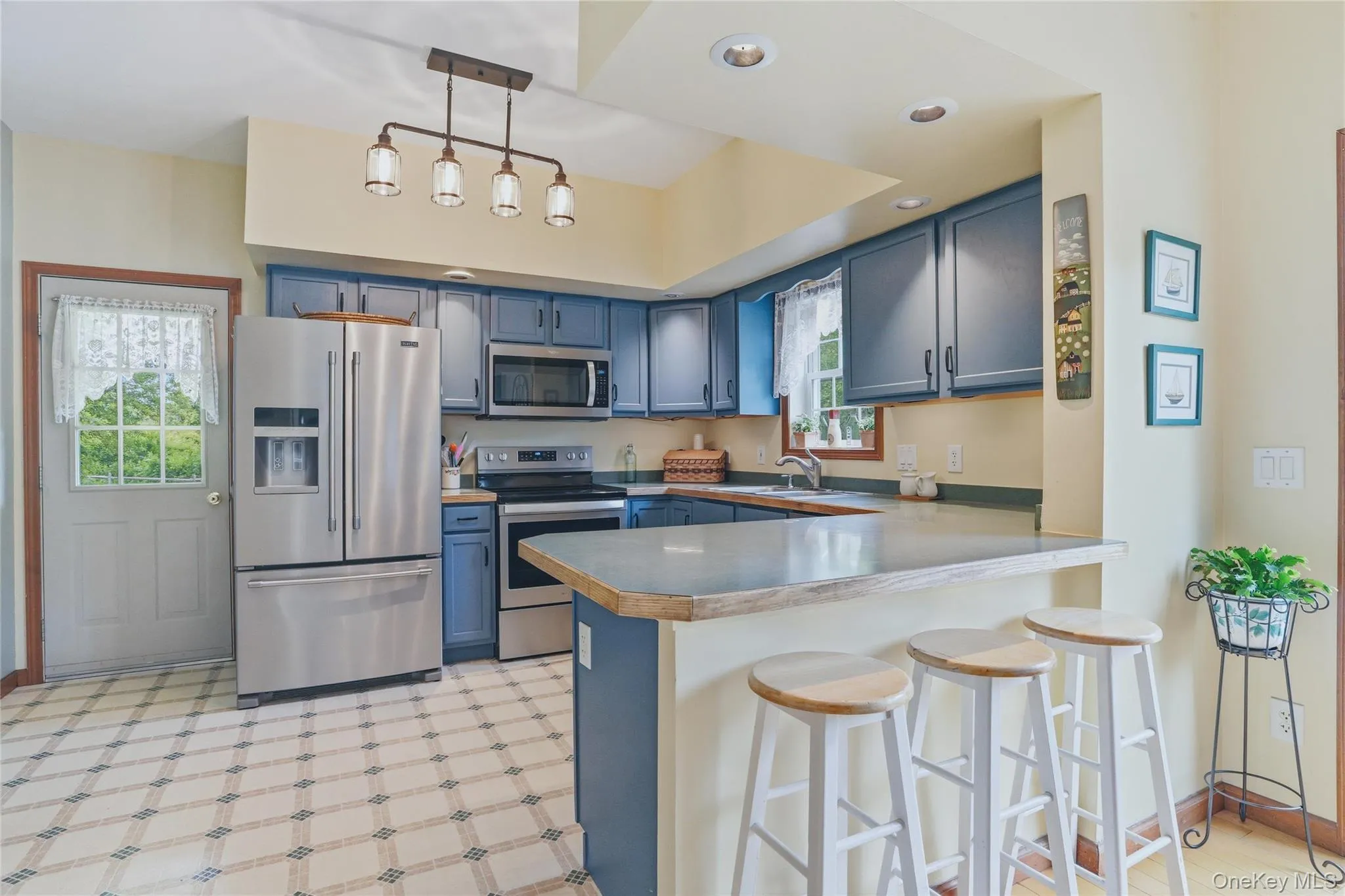 Kitchen with blue cabinets, stainless steal appliances and bar height counter with seating Kitchen with blue cabinets, stainless steal appliances and bar height counter with seating