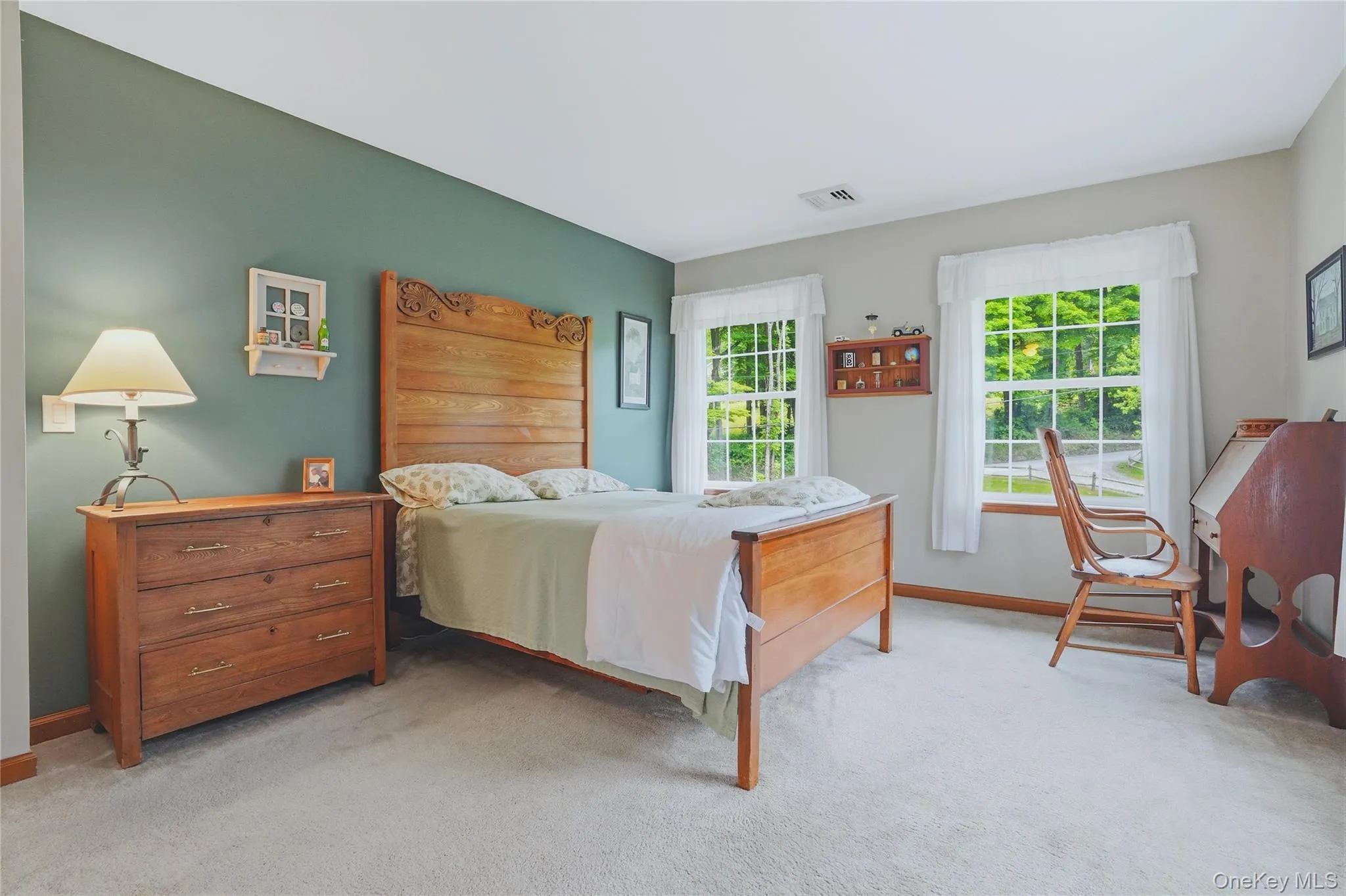 Primary bedroom with accent wall and grey carpet Primary bedroom with accent wall and grey carpet
