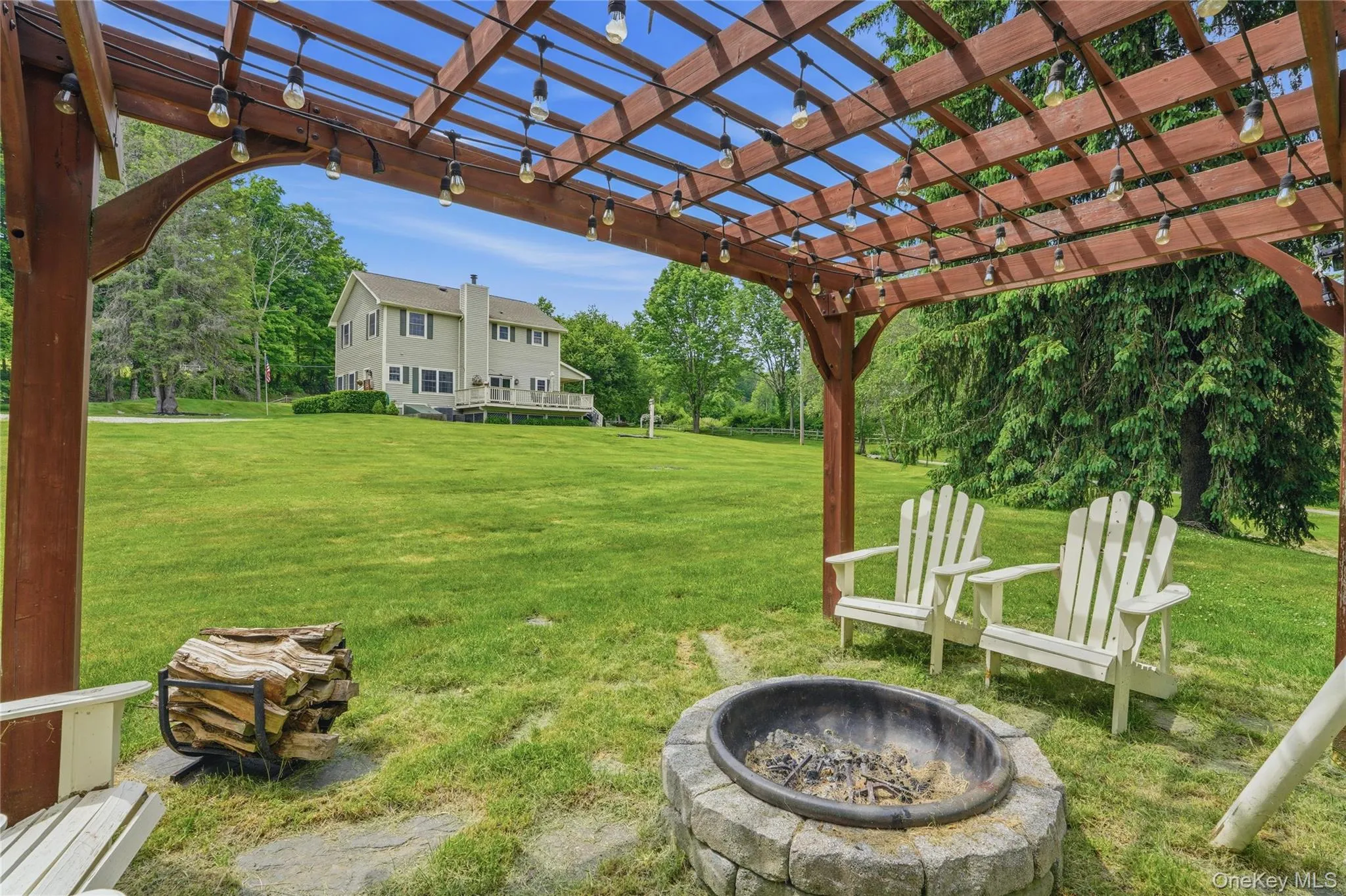 Pergola and firepit with home in background Pergola and firepit with home in background