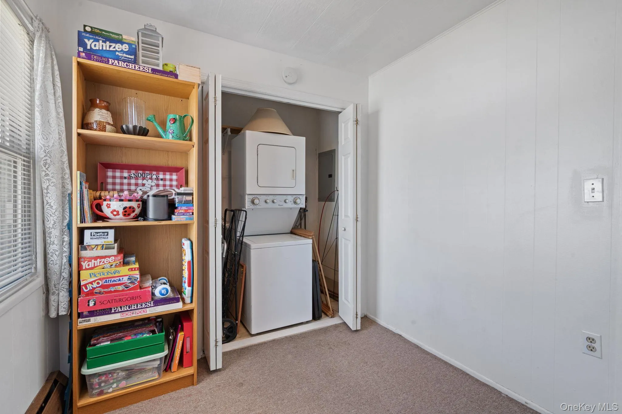 Dedicated laundry closet with stacked washer and dryer, providing functional utility Dedicated laundry closet with stacked washer and dryer, providing functional utility