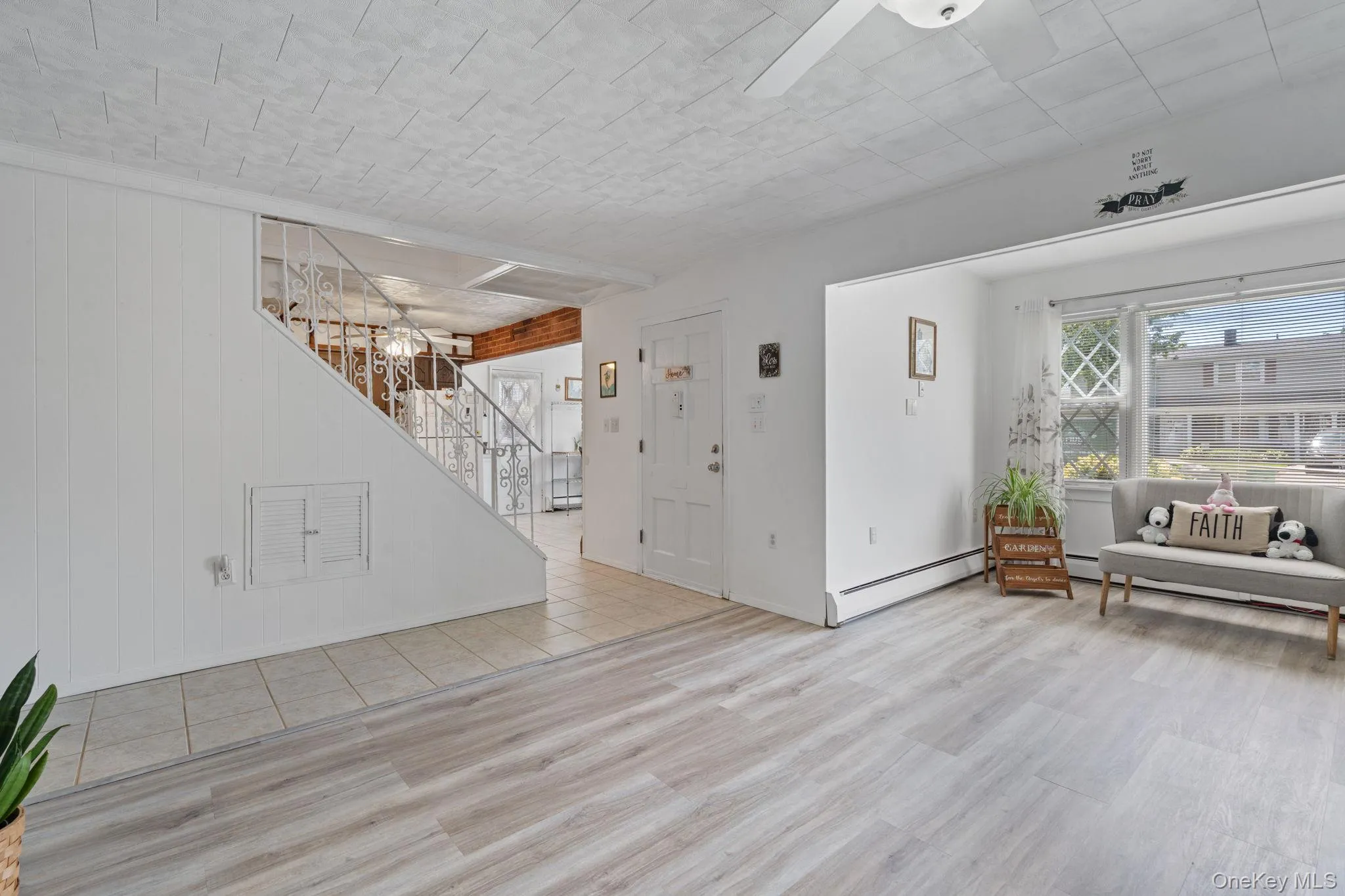 Open concept living space featuring wood-finish flooring, a white ceiling fan Open concept living space featuring wood-finish flooring, a white ceiling fan