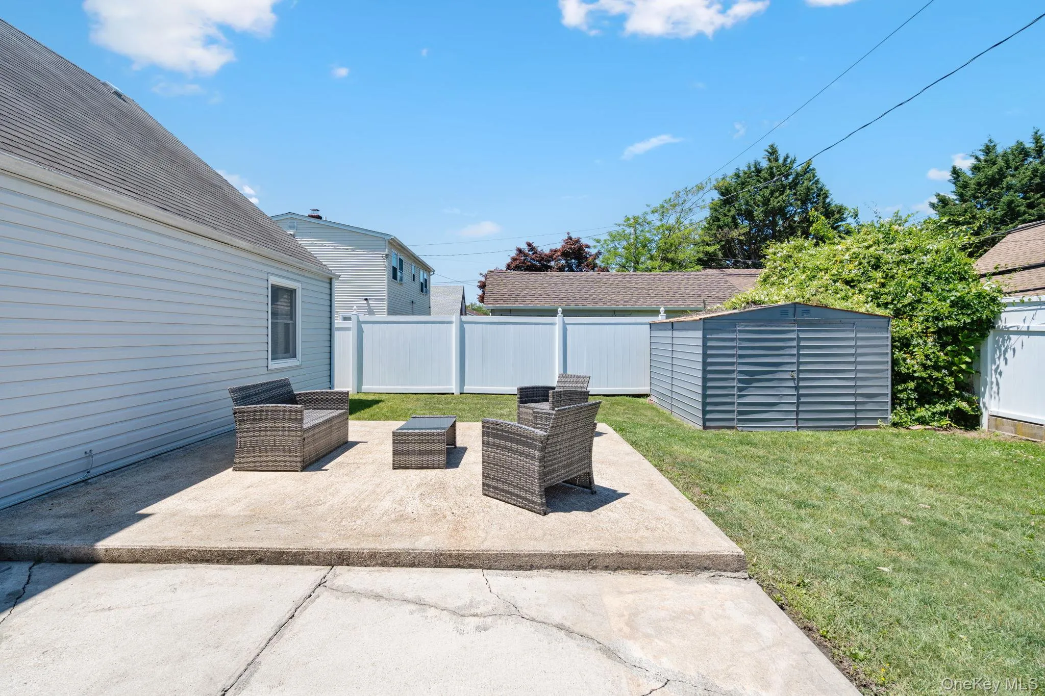 Expansive concrete patio with a surrounding lawn Expansive concrete patio with a surrounding lawn