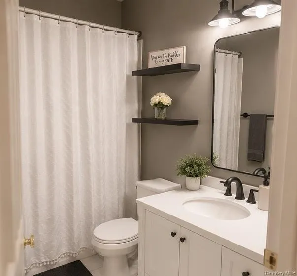 Bathroom featuring a white vanity with a solid surface countertop and undermount sink, matte black faucet, and a contemporary wall mirror Bathroom featuring a white vanity with a solid surface countertop and undermount sink, matte black faucet, and a contemporary wall mirror
